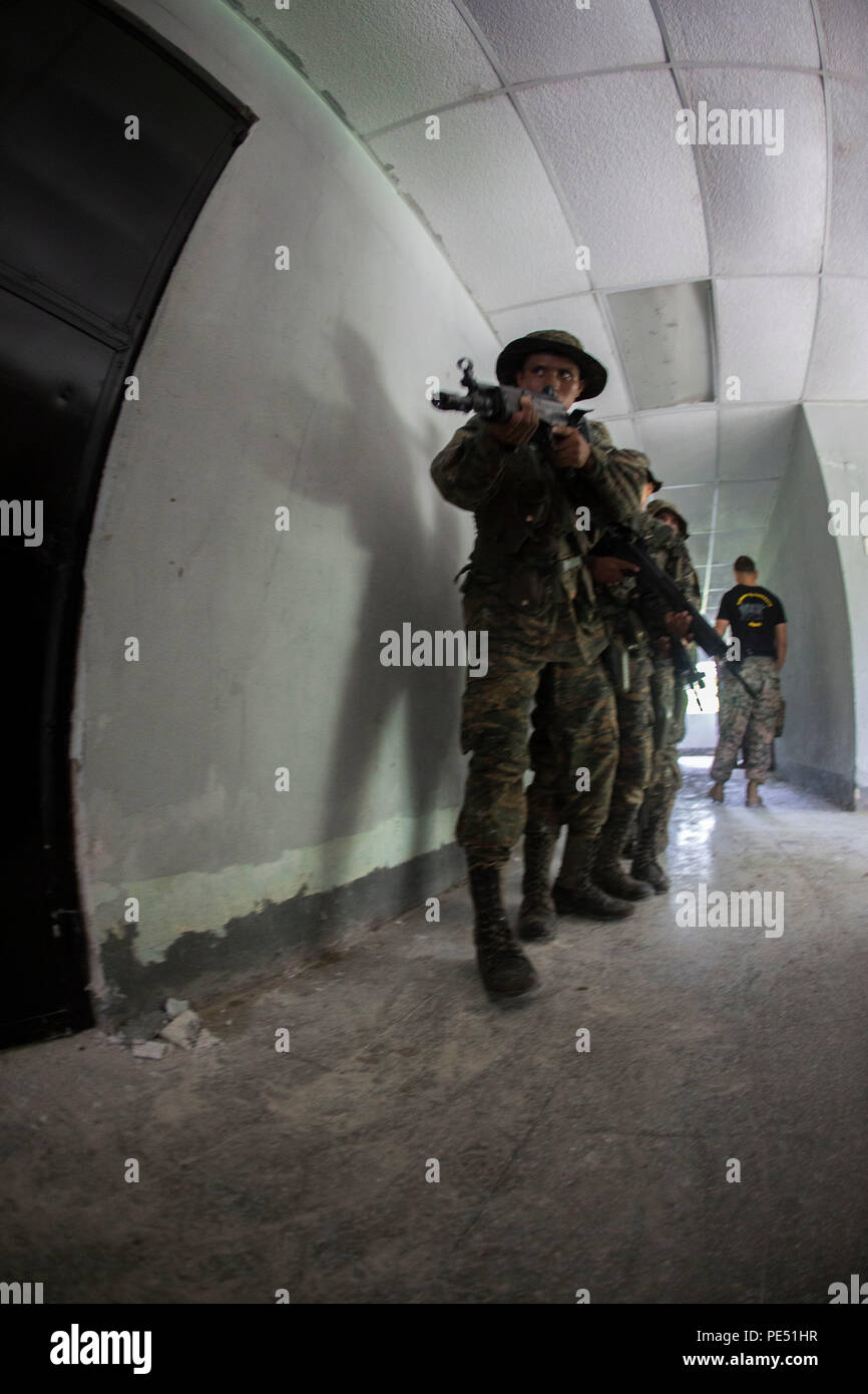 Les Marines et les soldats avec Brigada de Infanteria Marina commencent en zone urbaine pendant un cours de combat urbain menée par les Marines américains avec la coopération de sécurité, Team-Guatemala objet spécial air-sol marin le Commandement Sud de l'Équipe spéciale à Puerto Barrios, Guatemala, 25 septembre 2015. SPMAGTF-SC est un déploiement temporaire de marines et marins dans tout le Honduras, El Salvador, Guatemala, Belize et en mettant l'accent sur la création et le maintien de la capacité de partenariat avec chaque pays à travers des valeurs communes, des défis et responsabilités. (U.S. Marine Corps photo par Lance Cpl. Abraham Lopez/Presse Banque D'Images