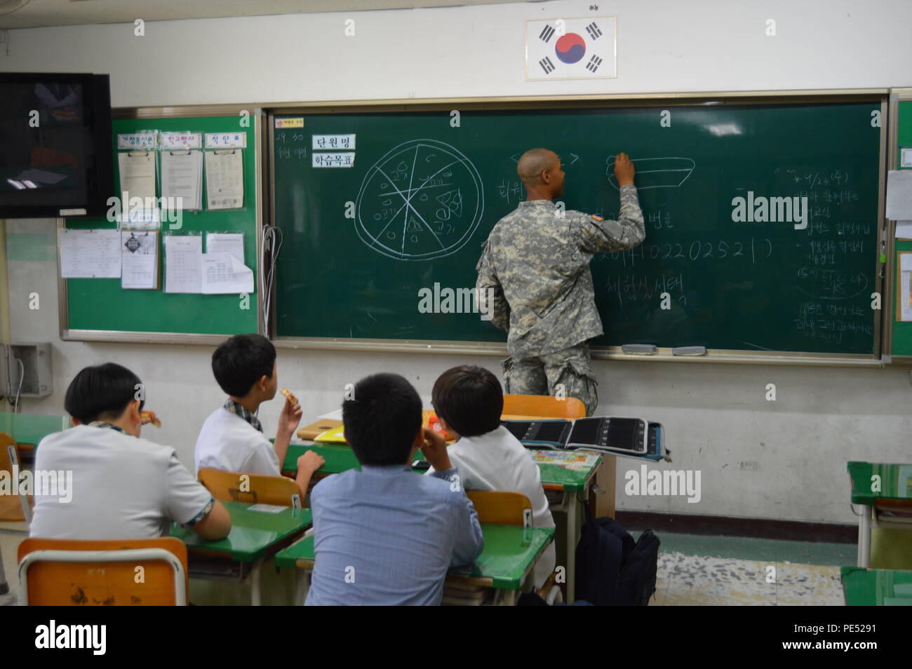 À l'école secondaire Kwonsun à Suwon, en Corée du Sud, un soldat du 6e bataillon du 52e régiment d'artillerie de défense aérienne a participé à un programme d'éducation culturelle le 23 septembre 2015. Quinze membres de l'armée américaine se sont portés volontaires pour enseigner l'anglais conversationnel et la culture américaine, en engageant les étudiants par le biais d'activités interactives comprenant le dessin, des discussions et des démonstrations. Ce programme fait partie du programme de bon voisinage des forces américaines – Corée, qui vise à favoriser les échanges culturels, les compétences linguistiques et les relations communautaires positives. Banque D'Images