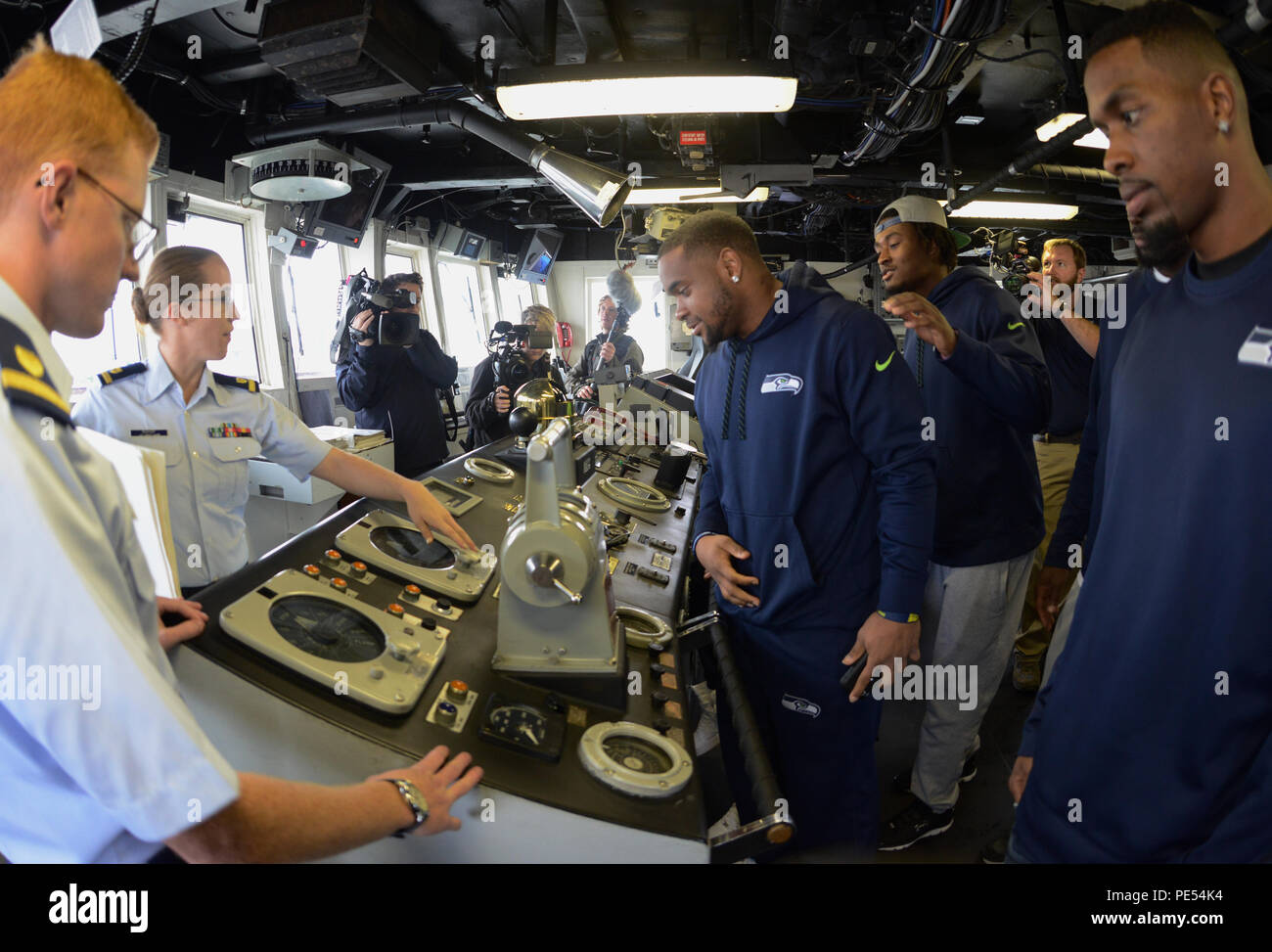 Ensign Abigail évêque et Ensign Joshua gémir donner un tour de garde-côte de Mellon, a 378 pieds de hauteur de coupe en homeported Endurance à Seattle, Seattle Seahawks joueurs et les filles de la mer, 13 octobre 2015. La visite a eu lieu au cours d'un changement de commandement à la base de la Garde côtière de Seattle, où les membres de la Garde côtière 13e arrondissement adopté sur les 12 d'un drapeau à la Marine Corps des Marines, les forces de sécurité de la Base navale Kitsap-Bangor-bataillon, après une année en tant que les Seahawks' honoré unité militaire. (U.S. Photo de la Garde côtière par Seaman Sarah Wilson) Banque D'Images