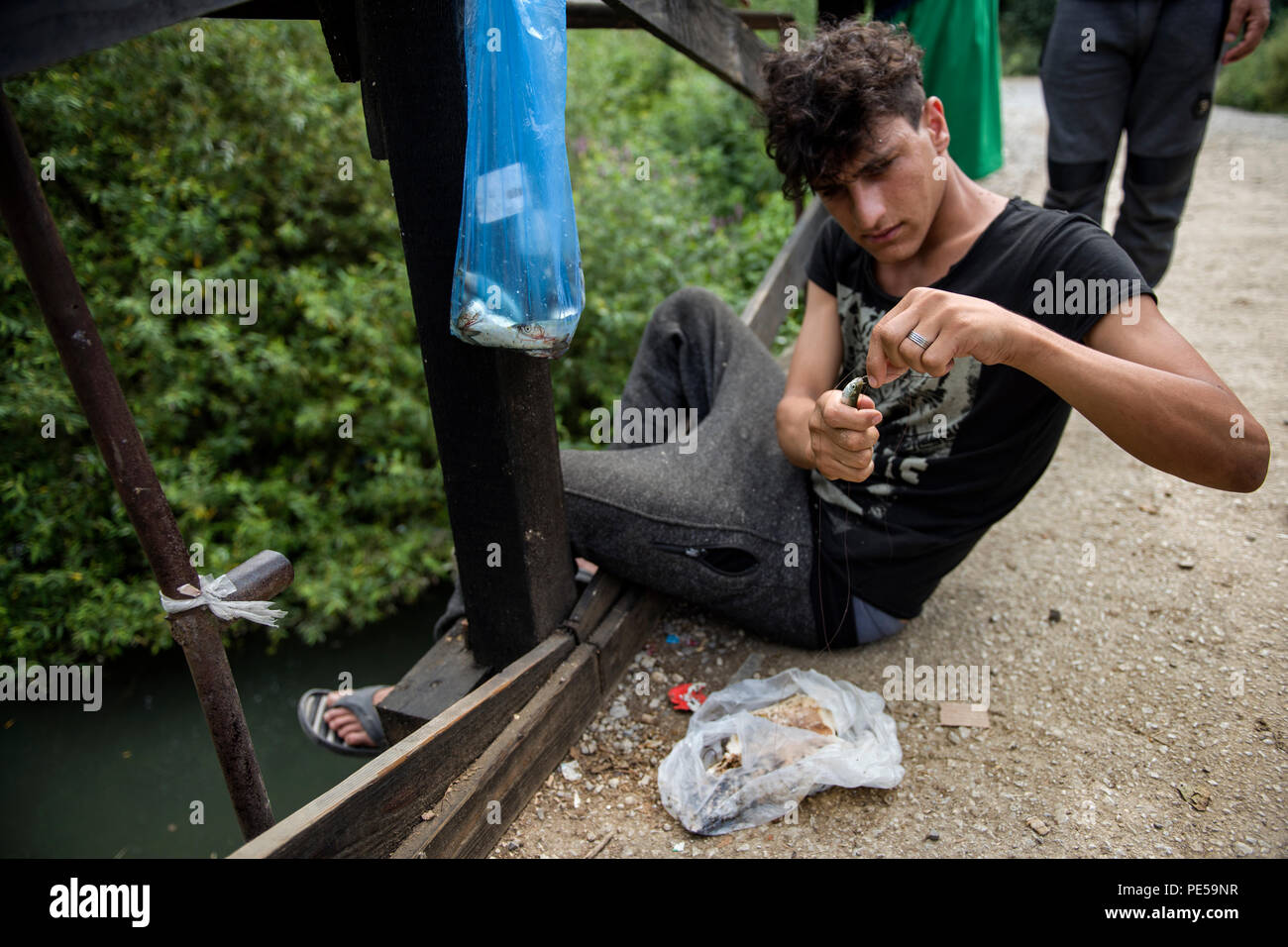 Les réfugiés vu pêcher dans la rivière à côté du camp. Les réfugiés qui tentent de s'infiltrer dans l'UE via la Bosnie vivent ici à Velika Kladusa dans de terribles et des conditions inhumaines dans une ville de tentes après la fermeture de l'ancienne route des Balkans, tentes improvisées sont surtout le seul toit pour homme, femme et enfants. Les gens essaient de traverser la frontière à travers le soi-disant 'jungle', mais après avoir entré la Croatie ils sont battus par la police, les téléphones sont écrasés et souvent l'argent est également supprimé. Après que les réfugiés sont repoussés à la Bosnie. Banque D'Images