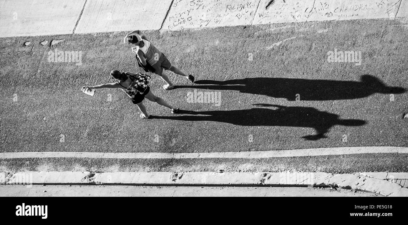 Silhouette d'un moulage de womans deux une grande ombre sur une route asphaltée. Banque D'Images