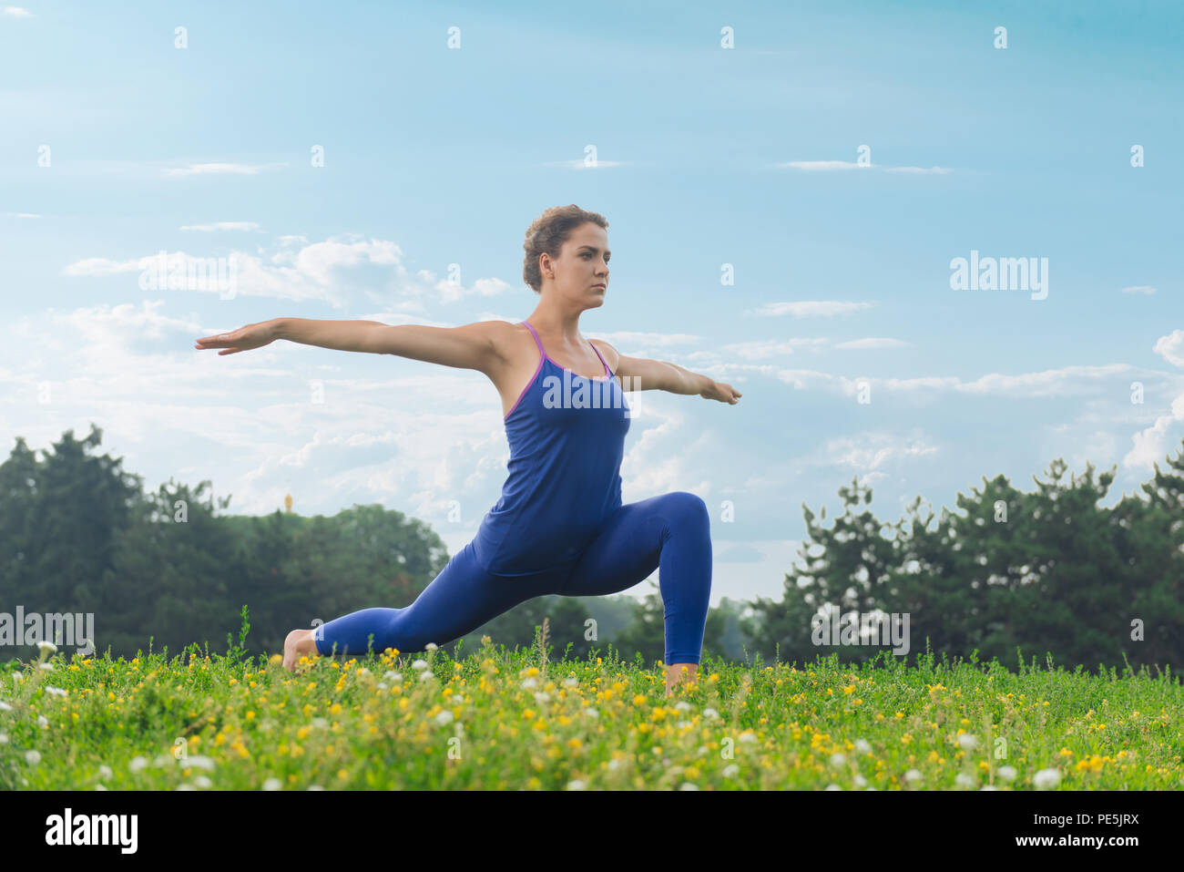 La sportive athlétique qui s'étend tout en faisant du yoga sur week-end Banque D'Images
