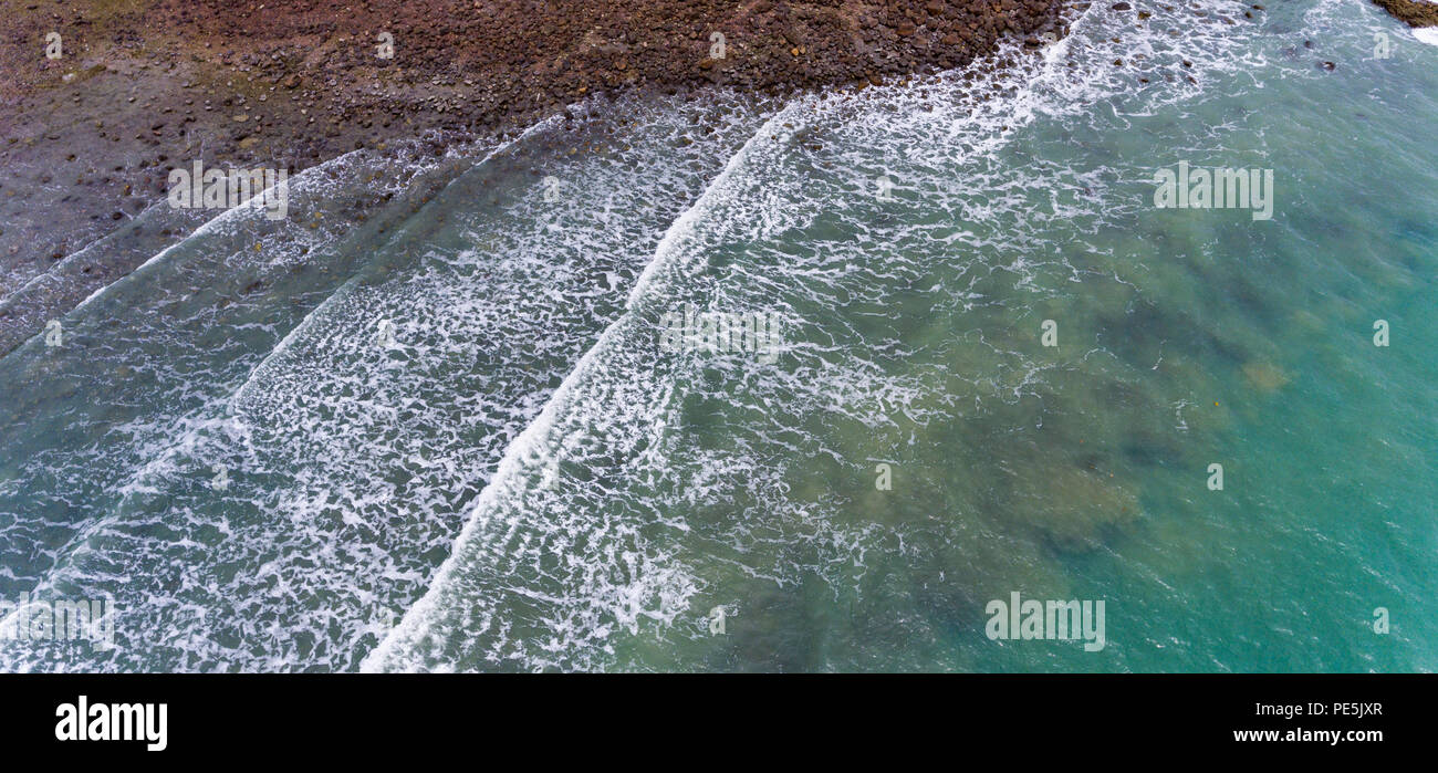 Vue aérienne d'une plage rocheuse et verte rive. Vagues se briser sur les rochers à côté de la végétation des arbres. Koh Chang, Thaïlande. Banque D'Images