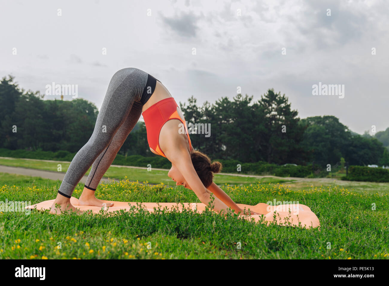 Yoga woman standing in bas poser dans la nature Banque D'Images
