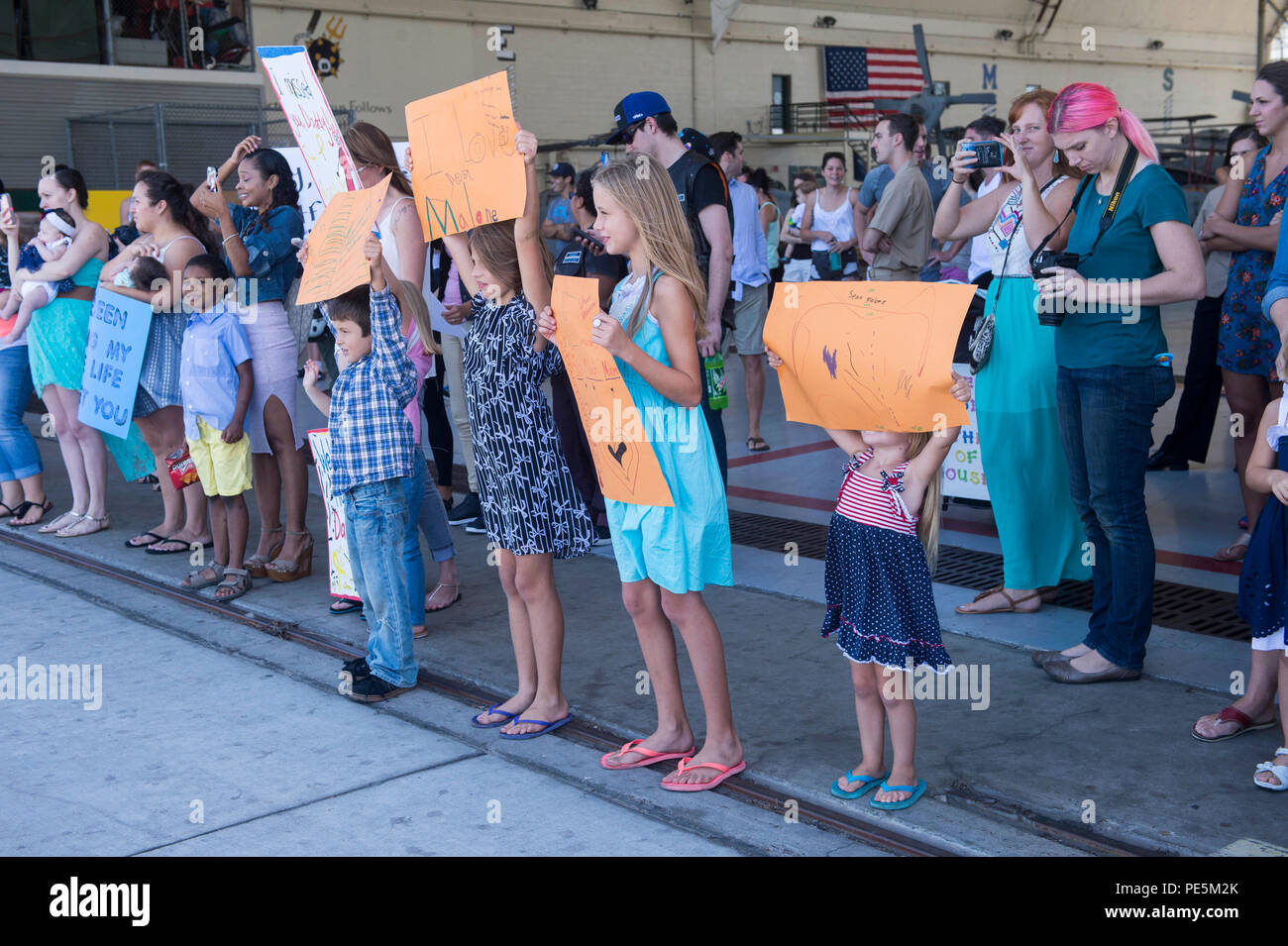 150926-N-IK388-021 CORONADO, Californie (sept. 26, 2015) - Des membres de la famille détiennent signes bienvenus dans un hangar qu'ils attendent le retour de leurs états de service au cours d'une fin de semaine pour hélicoptère de combat maritime Squadron (HSC) 21 au Naval Air Station North Island. HSC-21 retournés à leur domicile après une station près de cinq mois de déploiement à l'appui du Partenariat du Pacifique 2015. (U.S. Photo par marine Spécialiste de la communication de masse Stacy M. Atkins Ricks/ libéré) Banque D'Images
