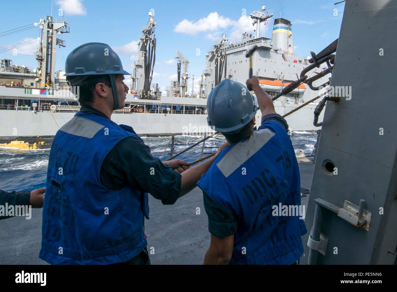 150929-N-AX546-158 MER MÉDITERRANÉE (sept. 29, 2015) Maître de Manœuvre Seaman Apprentice Josh Adams, de Greenfield, Indiana, à gauche, et maître de Manœuvre 3 classe Anthony Sanchez, de Hammond, Ind., libérer un fil haute tension à partir d'un oeil du patin à bord de l'USS Porter (DDG 78) au cours d'une reconstitution en cours avec le transport maritime militaire flotte commande reconstitution oiler USNS Leroy Grumman (T-AO 195) 29 septembre, 2015. Porter, une classe Arleigh Burke destroyer lance-missiles de l'avant-déployé à Rota, en Espagne, est en patrouille dans la conduite des opérations navales dans la sixième flotte américaine dans la zone d'opérations Banque D'Images