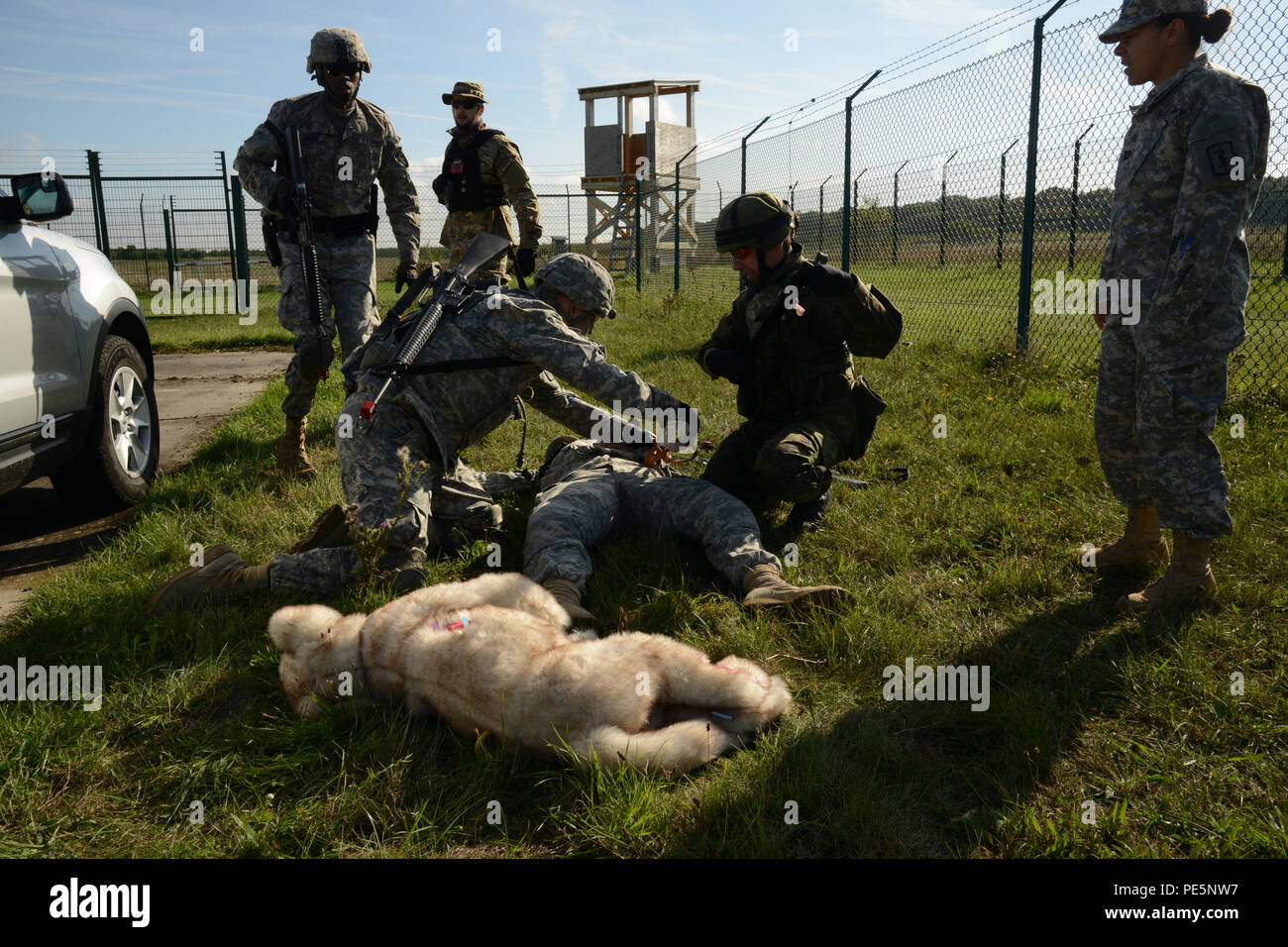 Des soldats. Le Sgt. Anthony Kozleuchar (centre aidant), avec l'APN, l'Europe travaille sur le Major Jodi Sanster, (U.S. Vétérinaire de l'armée, victime simulée), ainsi qu'un soldat de la Finlande, (à genoux), montrent comment aider une personne, et un chien de travail militaire victime qui a été blessé au cours d'un Combat International des sauveteurs qu'a organisé le 24 septembre 2015, au centre de formation à Finthen, Allemagne. (U.S. Photo de l'armée de l'information visuelle Dee Spécialiste Crawford/libérés) Banque D'Images