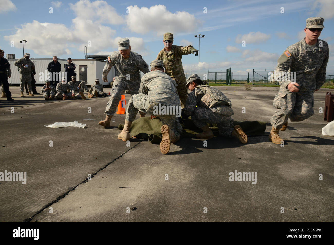 Professeur Tim Cranton (orienté), SPC Vanessa Nguyen avec USAREUR HHBN (à genoux en arrière droite), SPC. Jesse Untalan (debout à l'avant), le Sgt. Anthony Kozleuchar et SPC. Richard Povian (tournant), chacun assigné à l'Europe de l'APN, d'une simulation de travail scène ensemble pour aider une victime qui était en feu durant la formation avec les sauveteurs de combat qu'a organisé le 24 septembre 2015, à la zone d'entraînement de Finthen, Allemagne. (U.S. Photo de l'armée de l'information visuelle Dee Spécialiste Crawford/libérés) Banque D'Images