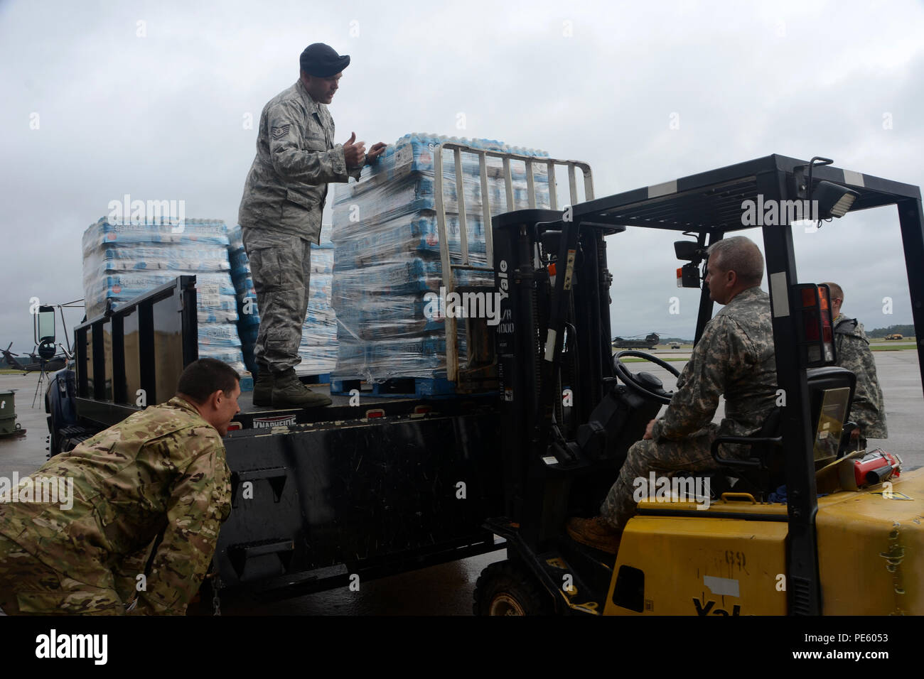 U.S. Air Force Tech. Le Sgt. Eric Peter, sous-officier responsable des systèmes de sécurité électronique affecté à la 169e Escadron des Forces de sécurité à la base de la Garde nationale mixte Guess, haut, de l'armée américaine et le Sgt. Bryan Baxley, une tôle aviation mécanicien affecté à la Compagnie Alpha, 1-111st, guide le Sgt. 1re classe Kenneth Erdel, chef d'un petit magasin, à droite, lors du déchargement de l'eau d'un camion pendant une inondation à l'échelle de réponse, le 5 octobre 2015 à la base de la Garde nationale mixte Guess, L.C. (Caroline du Sud La Garde nationale a été activé à l'appui de l'état et les organismes de gestion de l'urgence un comté Banque D'Images