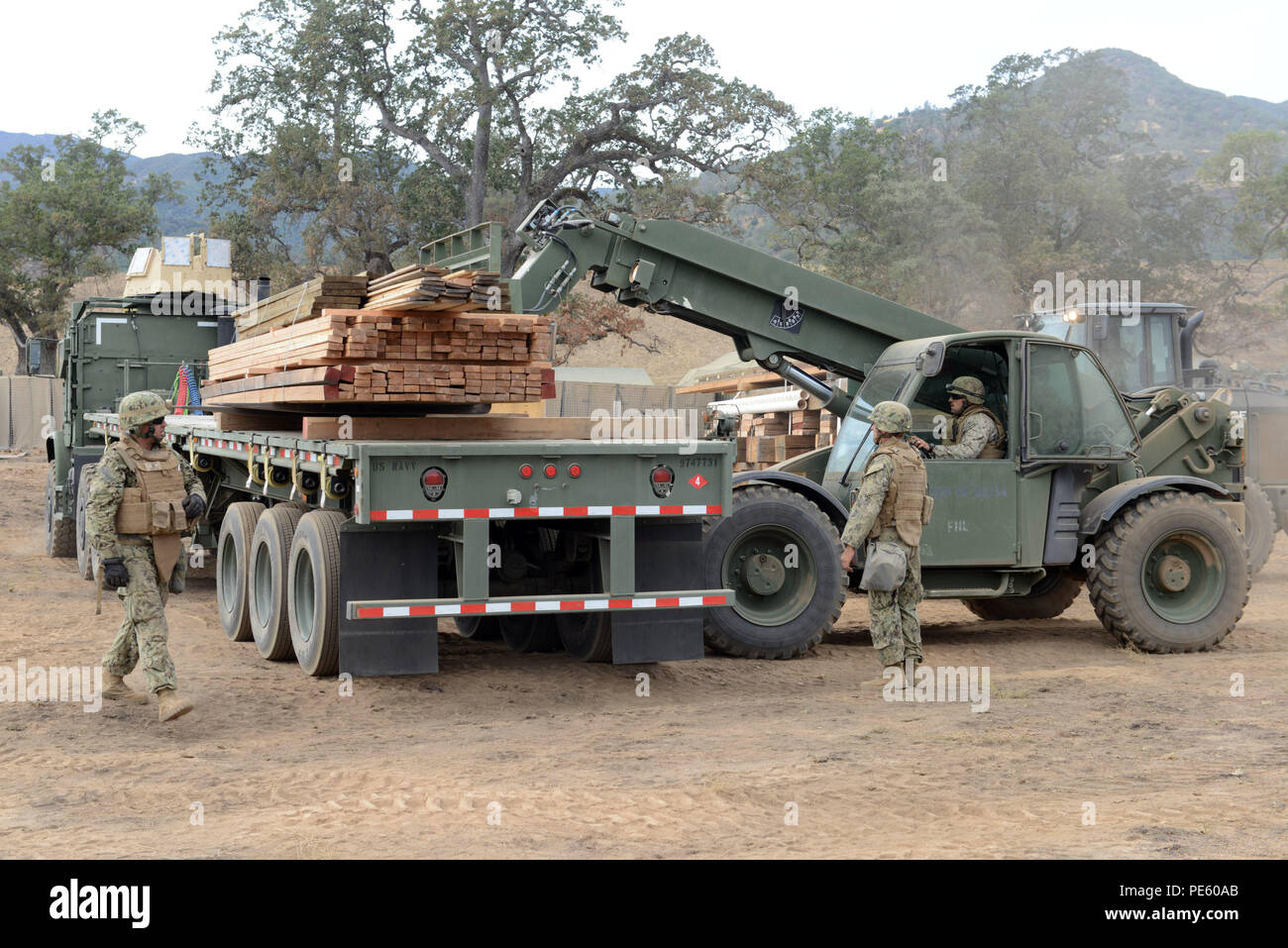 150928-N-DH124-069 FORT HUNTER LIGGETT (sept. 28, 2015) attribué à Seabees Mobile Naval Construction Battalion (NMCB), 4 palettes de déchargement à partir d'une remorque lors NMCB 4 exercice de formation sur le terrain (FTX). Prépare et FTX teste la capacité du bataillon d'entrer dans des endroits hostiles, construire des projets de construction attribué et se défendre contre les attaques ennemies, à l'aide de scénarios réalistes. (U.S. Photo par marine Spécialiste de la communication de masse 1re classe Rosalie Chang/libérés) Banque D'Images