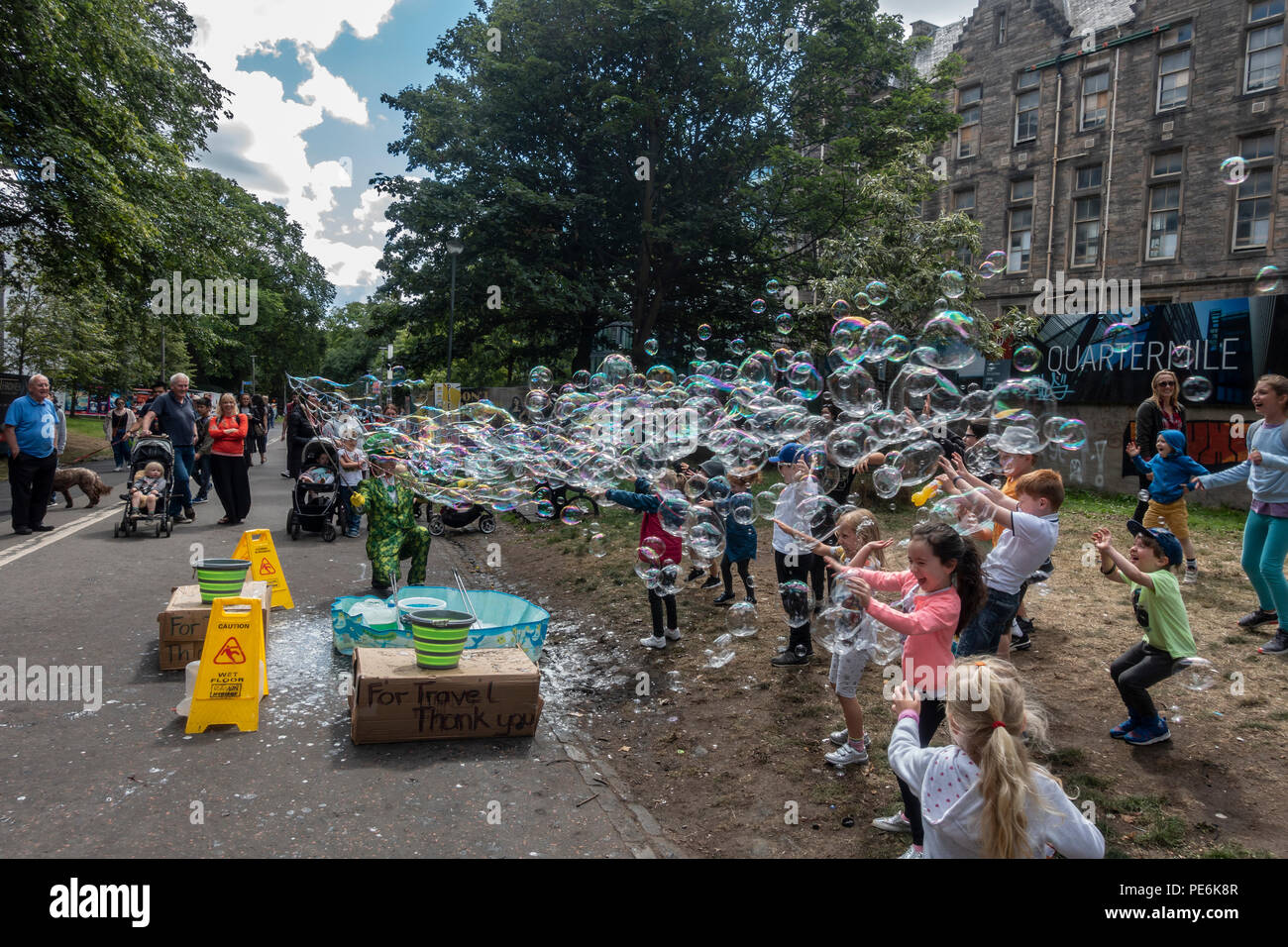 Artiste de rue, Freakbubbles distraire les enfants avec des masses de bulles dans la prairie au milieu de marche, Edinburgh, Edinburgh Festival Fringe pendant. Banque D'Images
