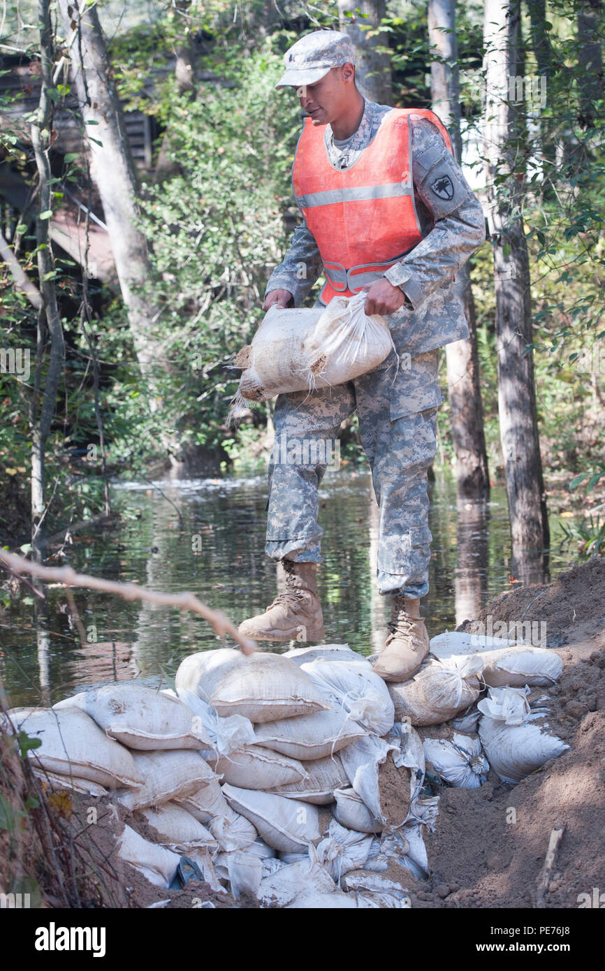 La Garde nationale de Caroline du Sud Le Sgt. Avec le 124e Chase Gambill Engineering Company de Saluda, S.C., place les sacs de sable pour endiguer un ruisseau pour arrêter temporairement l'écoulement de l'eau comme une équipe d'ingénieurs travaillent pour remplacer un ponceau emporté sur une route de comté de Lexington Gilbert, S.C., le 24 octobre 2015. La Caroline du Sud avec des soldats de la Garde nationale de l'Armée de continuer à fournir un soutien direct pour rétablir des inondations et des réparations d'urgence à la suite des récentes inondations. La Garde nationale de Caroline du Sud a établi un partenariat avec les gouvernements fédéral, étatiques et locaux des organismes de gestion des urgences et premiers intervenants. (U.S. Banque D'Images