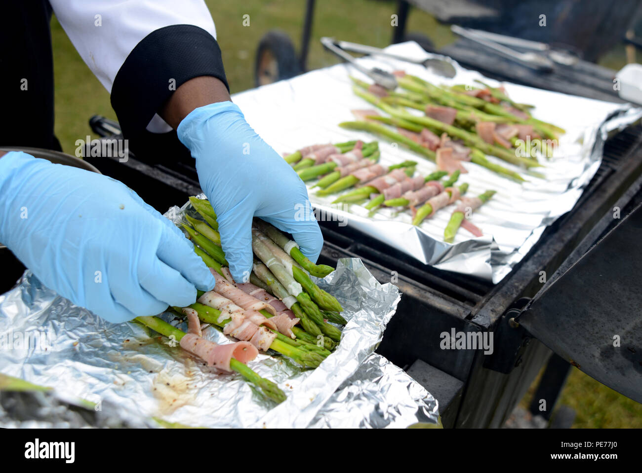 Joint Base Elmendorf-Richardson Équipe Culinaire cook PFC. Allan Wright places agrémentées de prosciutto asperges sur le grill de l'Alaska State Fair 2015 Boeuf Showdown, le 6 septembre. Ce plat final composé d'Épinards et provolone bavette farcies de fromage aux herbes, les croquettes, parsemées de prosciutto asperges, tomates grillées au feu et une purée de carottes. Le concours comprend trois équipes, chacune faisant trois plats principaux pour les juges et d'environ 300 échantillons pour la foule. (U.S. Air Force photo/Navigant de première classe Christopher R. Morales) Banque D'Images