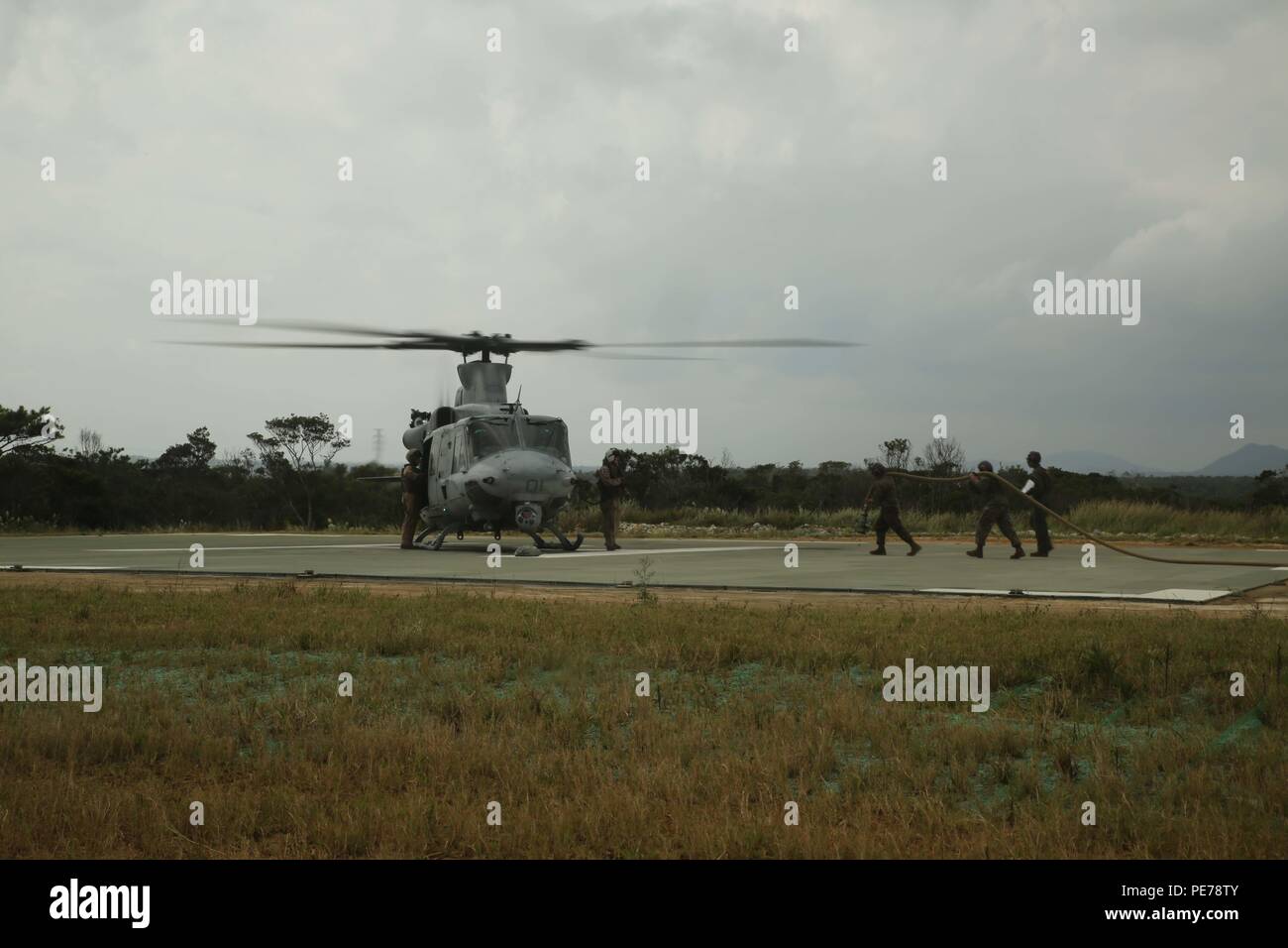 Marines Marines avec l'Escadron de soutien de l'Escadre 172 Mettre un tuyau de carburant aux pilotes d'un Huey UH-1Y bleu au cours de la chromite, dans la zone d'atterrissage de Phoenix, Camp Schwab, Okinawa, Japon, le 31 octobre 2015. Marines avec MWSS-172, qui relève de l'air marin, 1er Groupe 36, aile d'avion Marine III Marine Expeditionary Force, avant l'exécution d'un armement et d'essence de fournir des aéronefs soutient également la chromite bleu avec du carburant pour continuer à défendre le sol de l'élément Maritime Aérien Au sol Groupe de travail. La chromite est bleu un débarquement de grande envergure qui attire principalement de l'exercice III MEF formation ressources sur Okinaw Banque D'Images