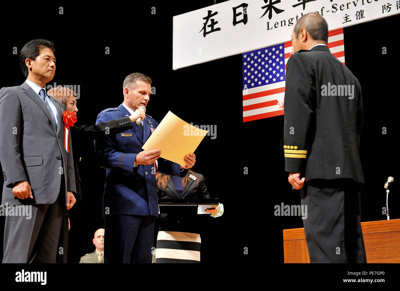 U.S. Air Force Brig. Le général Barry Cornish, 18e Escadre, lit un certificat de mention élogieuse à Mitsuo Yamaguchi, 18e Escadron de génie civil section formation incendie, adjoint au nom de la Kadena Air Base employés locaux au cours d'une durée de Service Award cérémonie à l'Okinawa Convention Center dans la ville de Ginowan, Japon, le 15 octobre 2015. Un total de 265 employés locaux de Kadena, ont reçu le Prix de la durée de service commun. (U.S. Air Force photo par Naoto Anazawa) Banque D'Images