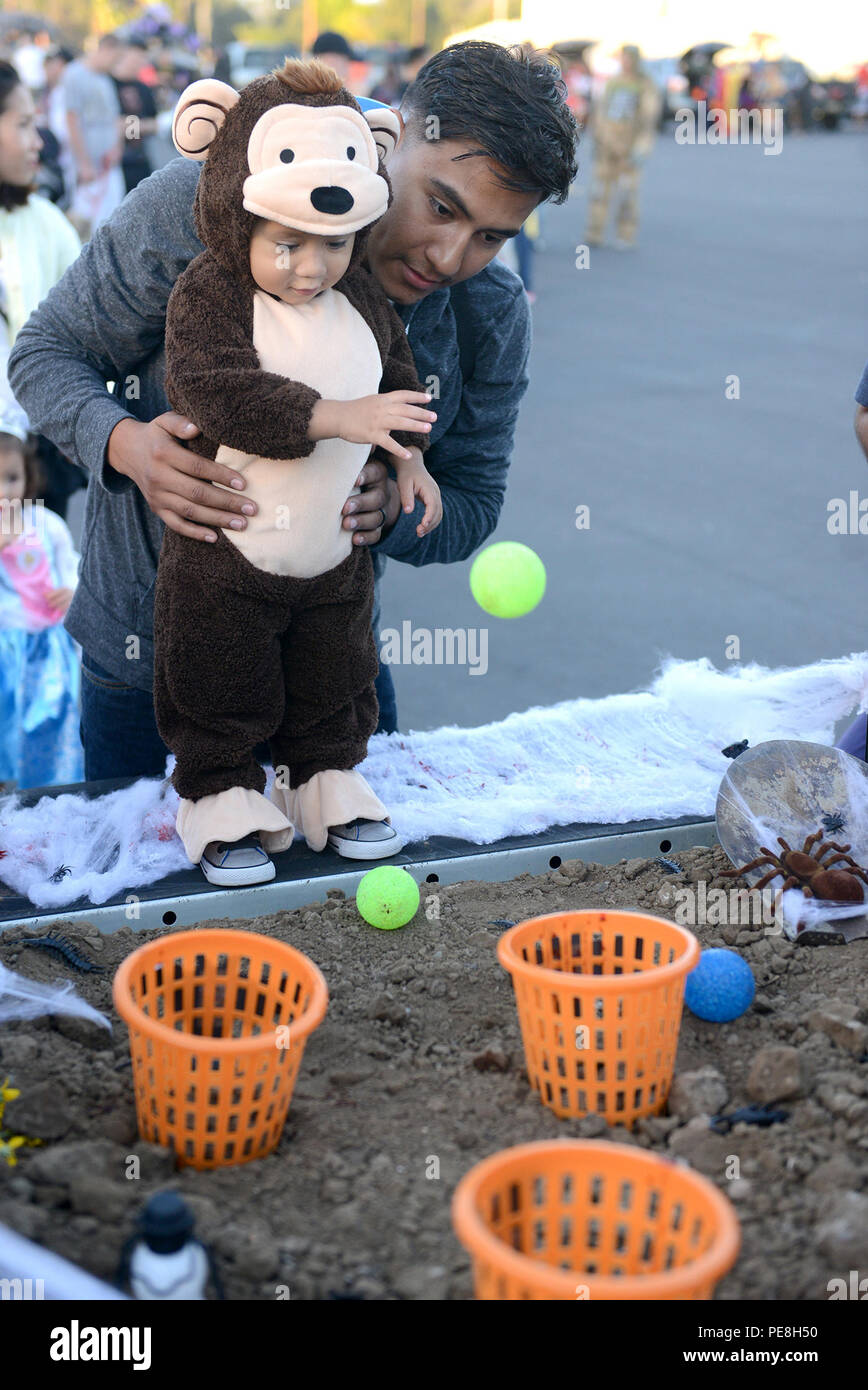 151028-N-SD120-015 NAVAL BASE comté de Ventura, Californie (28 octobre 2015) Opérateur de l'équipement 3 Classe Jacob Soliz joue un jeu avec son fils au Bataillon mobile de construction navale (NMCB) 5 coffre ou traiter l'événement. La famille du bataillon groupe de préparation (RFA) a accueilli l'événement pour les amis et les familles à prendre part à un événement d'Halloween en toute sécurité. (U.S. Photo par marine Spécialiste de la communication de masse 1re classe John P. Curtis/libérés) Banque D'Images