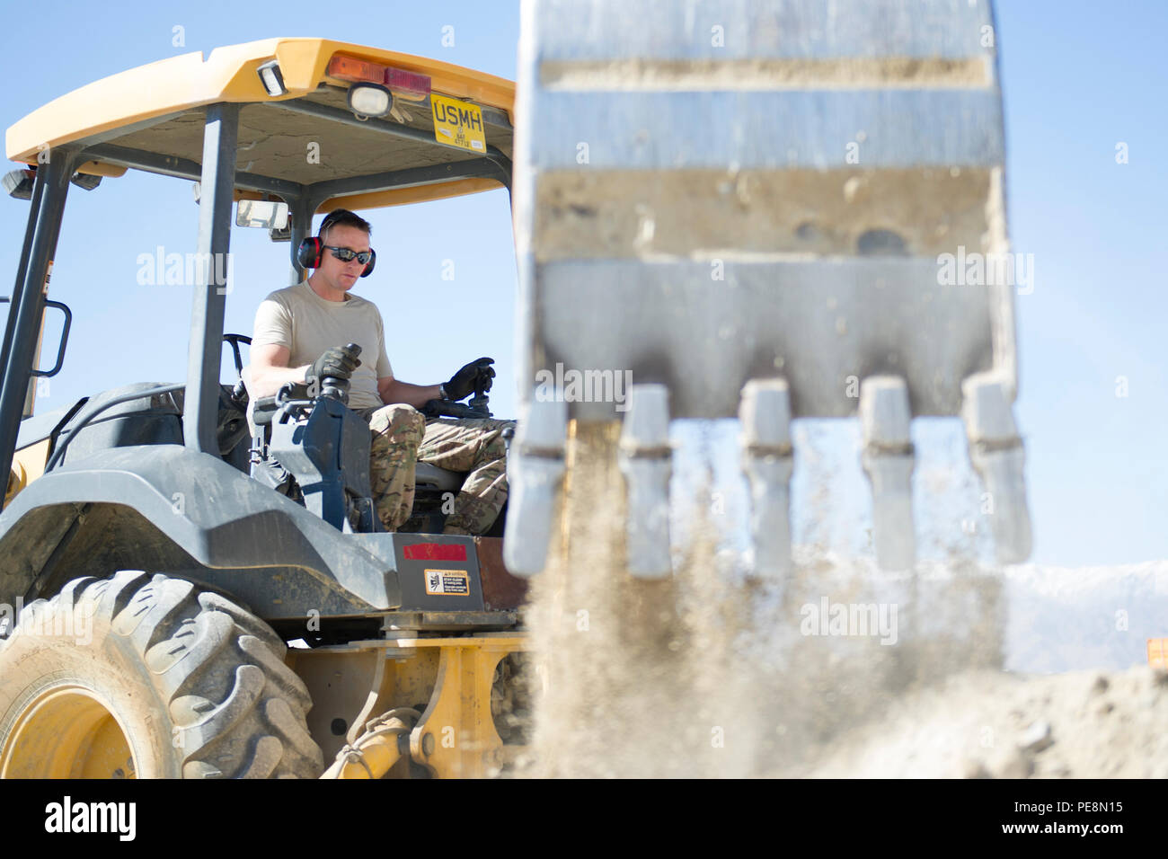 Un technicien du 455e Escadron expéditionnaire du génie civil exploite une pelleteuse à Bagram Air Field, en Afghanistan, le 4 novembre 2015. Les « Dirt Boys » ont préparé un site de ciment pour une structure d'entretien de grande surface, effectuant le nivellement du sol, le nivellement et l'utilisation de l'équipement pour assurer le soutien structurel et la préparation. Les travaux appuient les projets de construction en cours et l'entretien des installations dans la zone opérationnelle déployée. Banque D'Images