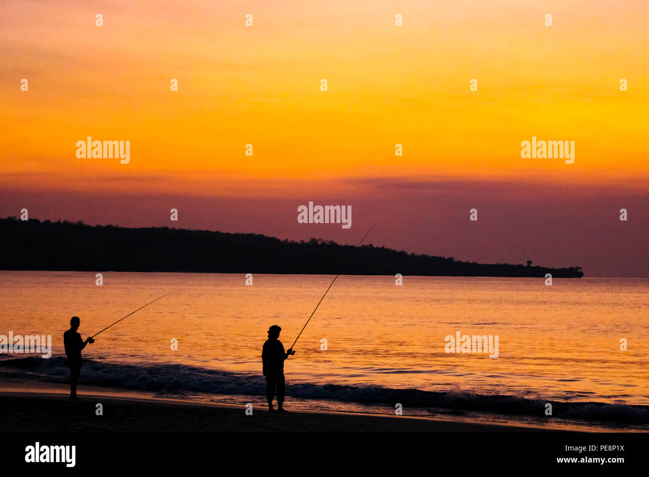 Les pêcheurs sur la plage de l'île de Bali au coucher du soleil. Banque D'Images