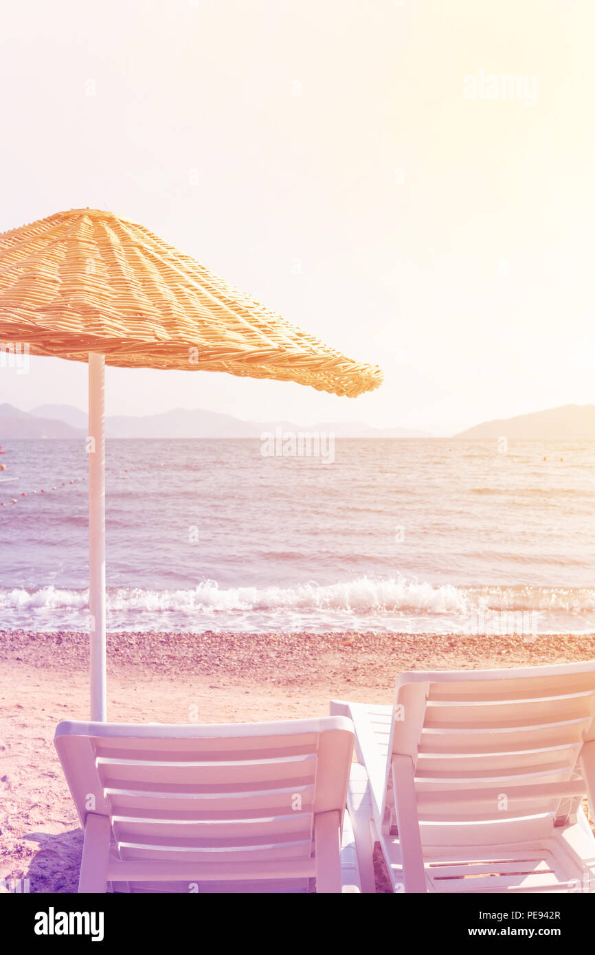Deux chaises longues et parasol sur la plage. Concept de vacances d'été. Banque D'Images