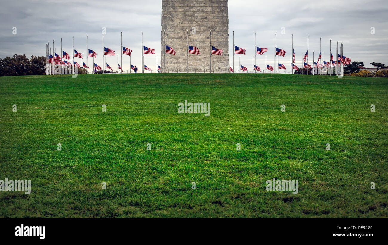 Un cercle de drapeaux américains en berne par la base du Monument de Washington à Washington DC. Banque D'Images