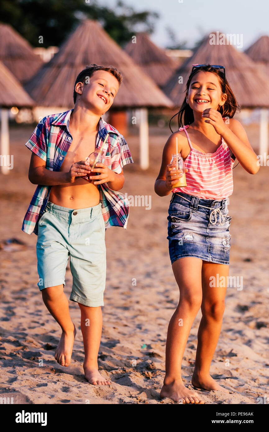 Heureux les enfants s'amuser tout en marchant le long d'une plage de sable. L'été et travel concept Banque D'Images