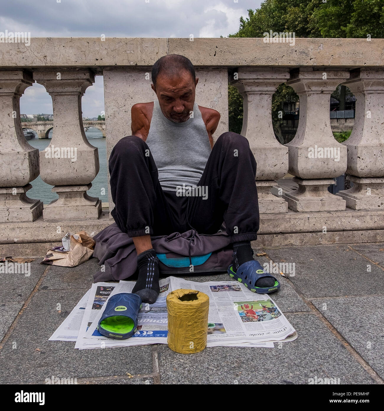 Mendiant sur un pont sur la seine, Paris, France Banque D'Images