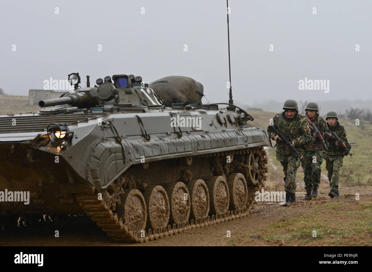 Soldats bulgares de 1-61er bataillon mécanisé Boyevaya Mashina Pekhoty suivi d'un BMP (1 -1) à travers la route boueuse pendant l'exercice à Novo Selo sentinelle de la paix Centre de formation, la Bulgarie, le 24 novembre, 2015. (U.S. Photo de l'armée par le sergent. Steven M. Colvin/libérés) Banque D'Images