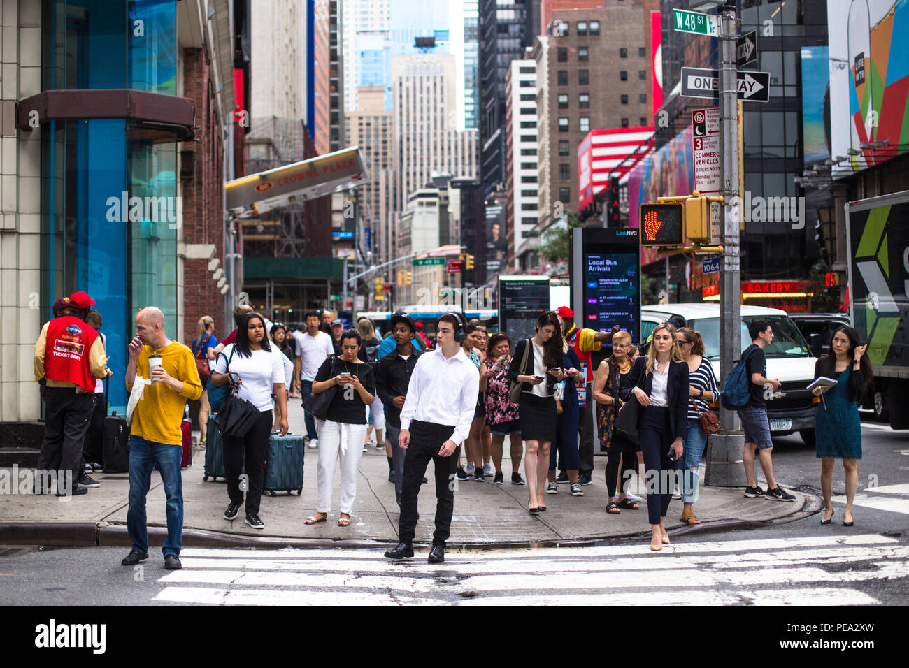 NEW YORK CITY - 26 juillet 2018 : trottoir occupé à Times Square à Manhattan encombrée de beaucoup de gens à pied et des panneaux publicitaires. Banque D'Images