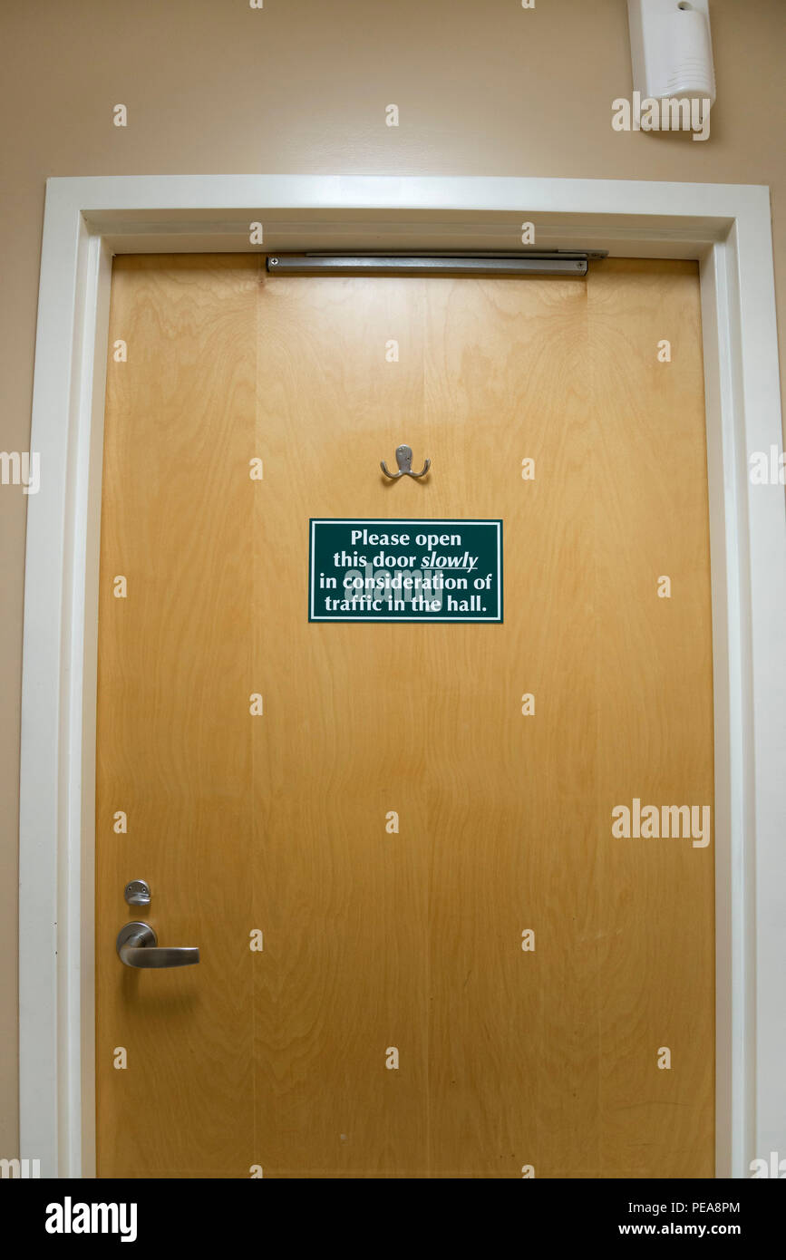 Attention sur un signe d'ouverture de porte de salle de bain public. Banque D'Images