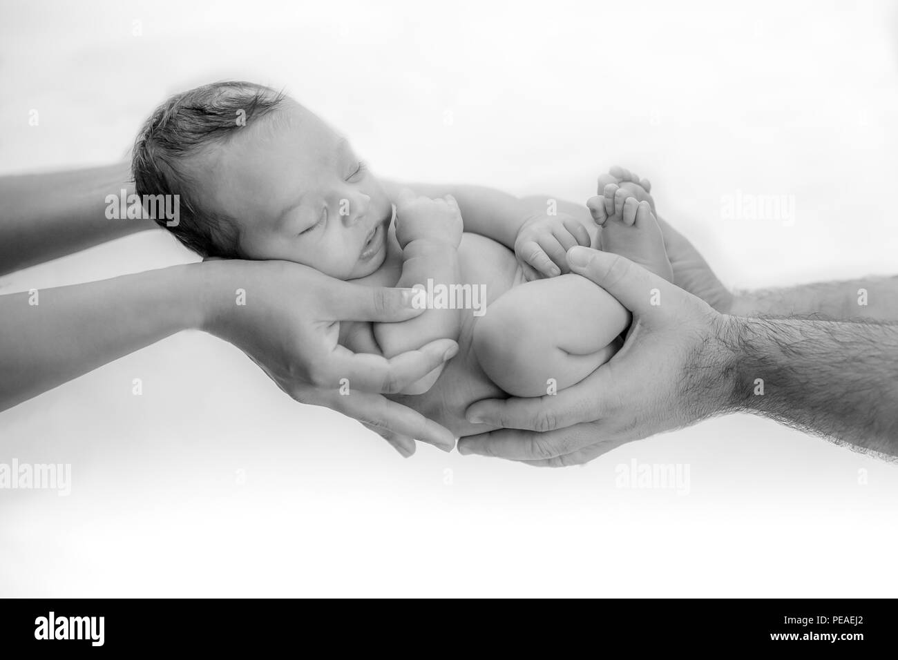 Mignon bébé nouveau-né dort dans les mains des parents protégé et en sécurité - heureux moments en famille pour maman et papa Banque D'Images
