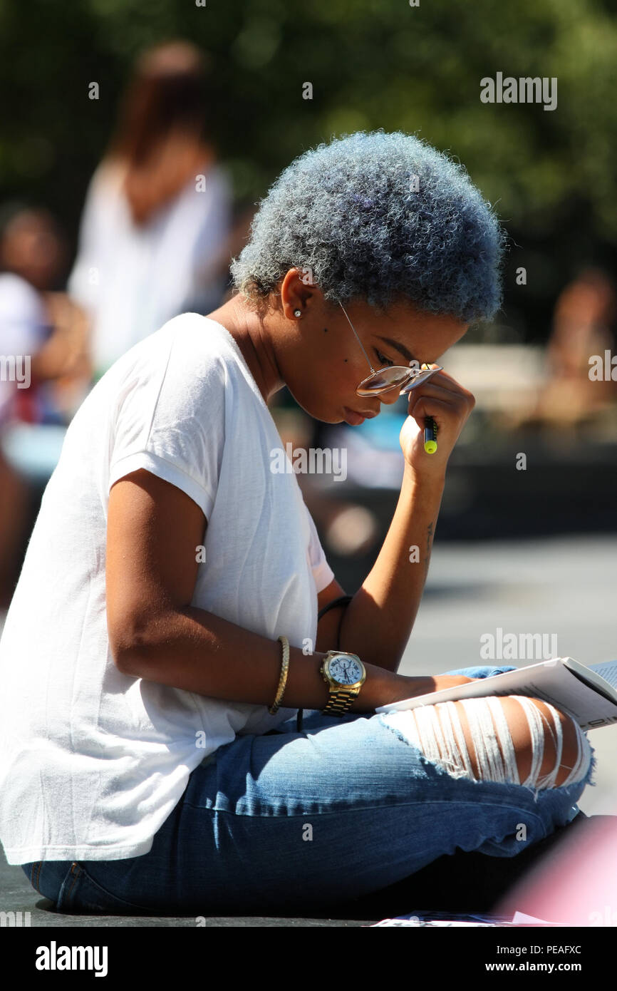 NEW YORK, NY - 02 SEPTEMBRE : Jeune femme noire d'étudier un livre tout en restant assis à Washington Square Park, à Manhattan, le 2 septembre 2016 à New York, États-Unis Banque D'Images