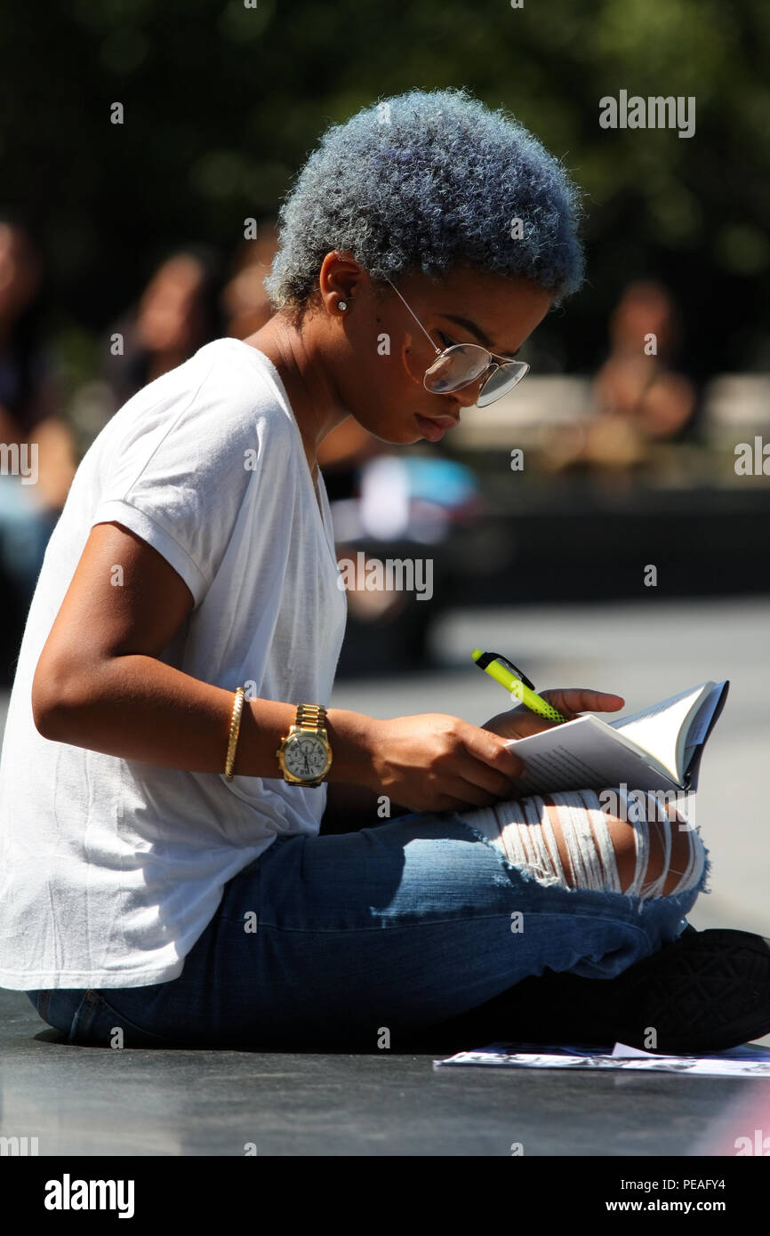 NEW YORK, NY - 02 SEPTEMBRE : Jeune femme noire d'étudier un livre tout en restant assis à Washington Square Park, à Manhattan, le 2 septembre 2016 à New York, États-Unis Banque D'Images
