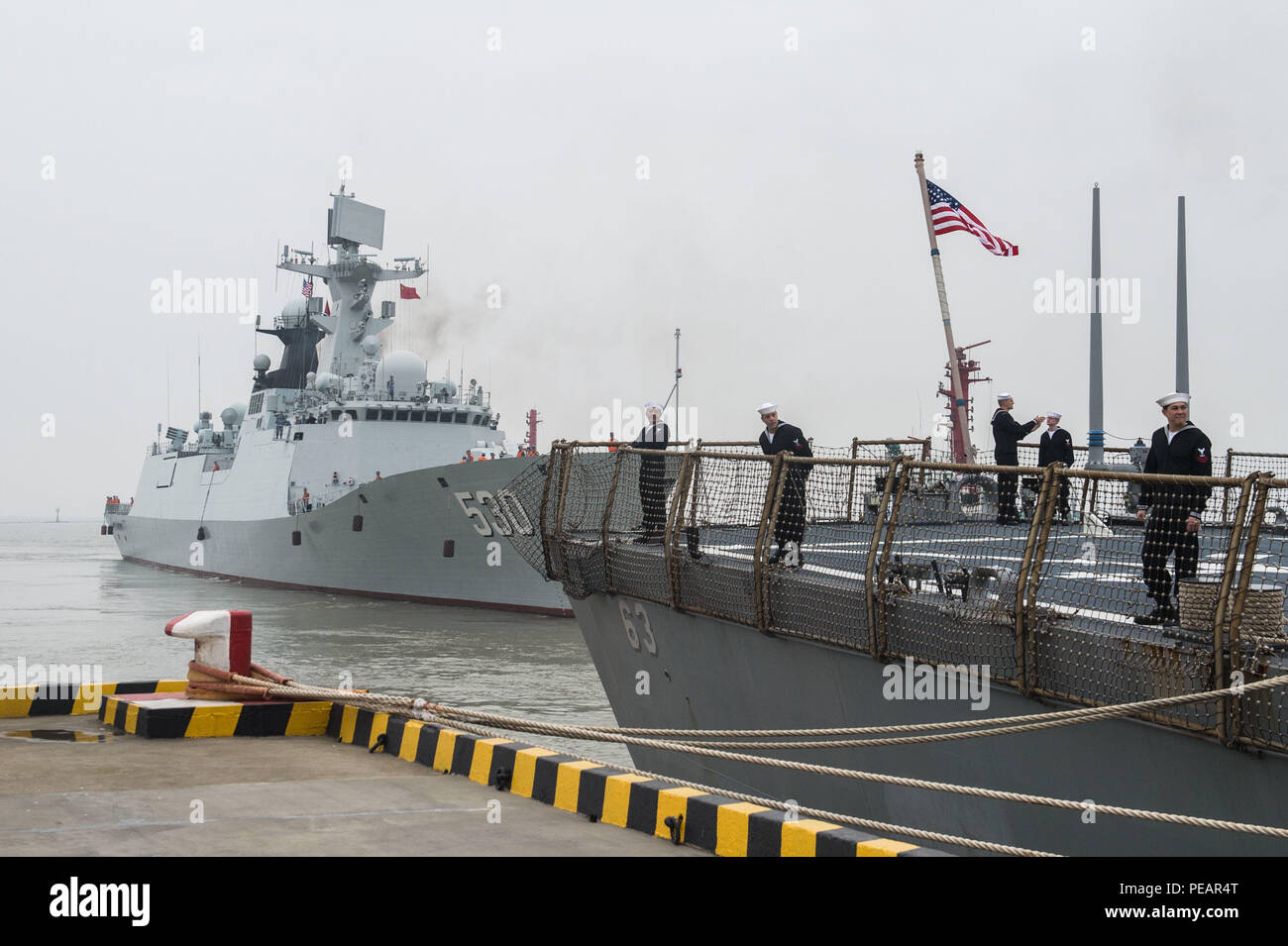 151120-N-UF697-067 SHANGHAI (nov. 20, 2015) Les marins à bord de l'avant-déployés de la classe Arleigh Burke destroyer lance-missiles USS Stethem (DDG 63) se préparent à quitter le port alors que l'Armée de libération du peuple Jiangkai Marine II classe frégate lance-missiles Linyi (FFG 530) est en cours. Stethem visité Shanghai à établir des relations avec la Marine de l'ALP et démontrer l'engagement de la Marine américaine à l'Indo-Asia-Pacifique. (U.S. Photo par marine Spécialiste de la communication de masse 2e classe Kevin C. Cunningham/libérés) Banque D'Images