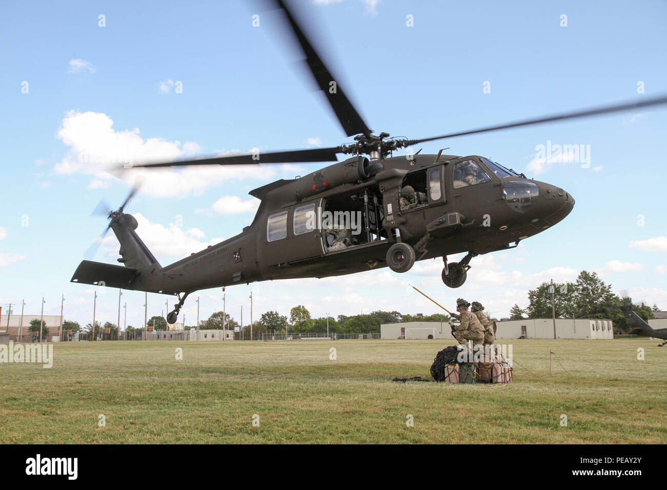 Un UH-60 Black Hawk se déplace dans une position stationnaire comme une équipe de soldats du 1er Bataillon, 506e Régiment d'infanterie, 1e Brigade Combat Team, 101st Airborne Division (Air Assault), préparez-vous à fixer une charge d'équipement pendant les opérations d'assaut aérien sur Johnson Champ à Fort Campbell, Kentucky, le 10 septembre, 2015. L'événement de formation fourni l'occasion de rafraîchir les dirigeants de leur charge sous élingue compétences, tout en les préparant à l'évaluation dans l'Armée Warfighter Fort Bliss, Texas, plus tard ce mois-ci. L'évaluation est un événement de trois semaines destiné à améliorer la formation interarmées et multinationales avec l'état de préparation Banque D'Images