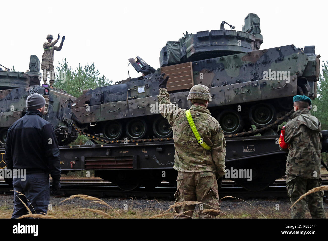 Soldats affectés à la société B et D, 3e Bataillon, 69e régiment de blindés, 1st Armored Brigade Combat Team, 3ème Division d'infanterie de travailler ensemble tout en aidant un véhicule de combat Bradley en place sur un chemin de fer pendant les opérations de tête, 2 décembre, au Camp Trzebien, Pologne. (U.S. Photo de l'armée par le Sgt. Paige Behringer, 10e Appuyez sur Camp de siège) Banque D'Images