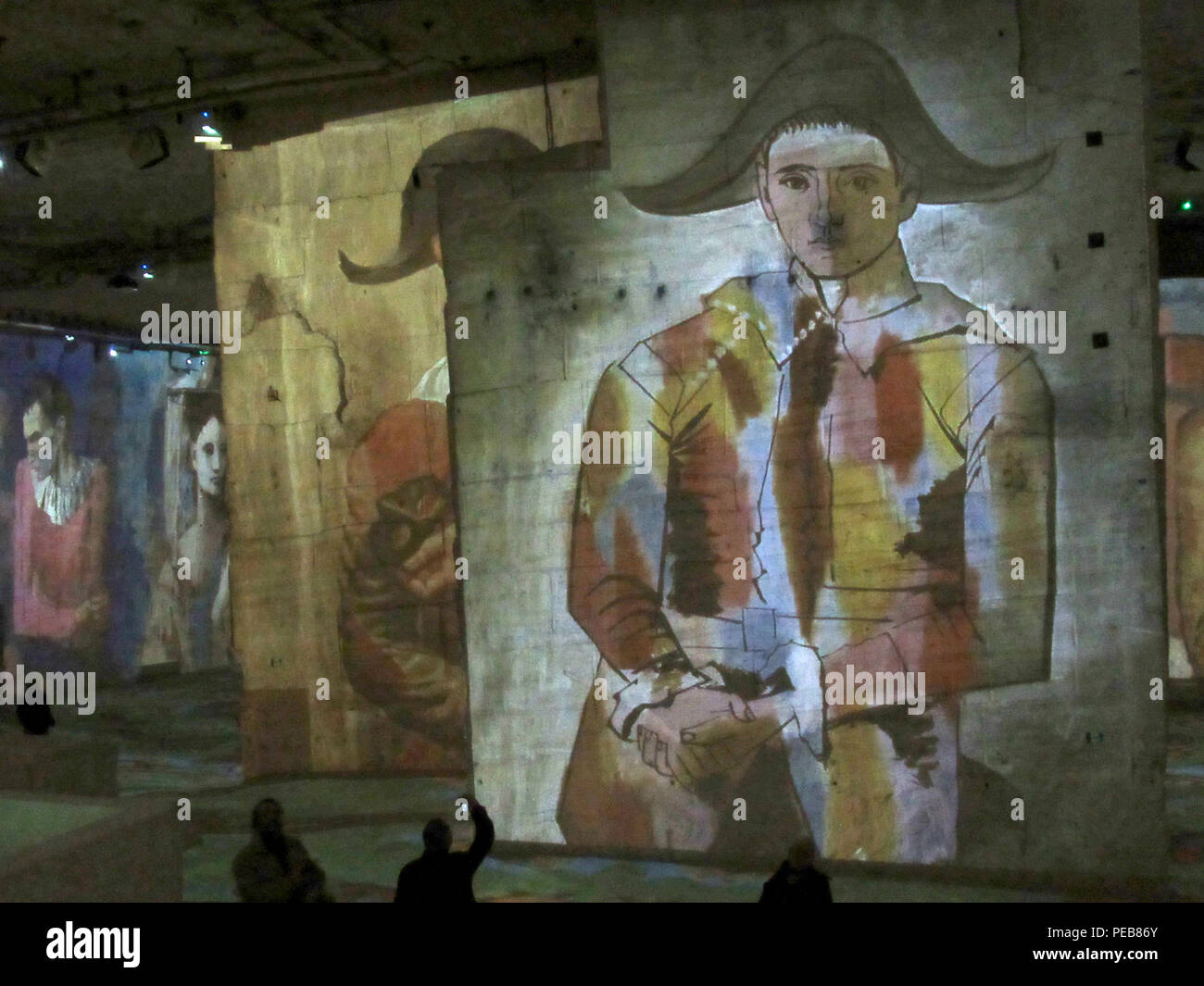 Les Baux-de-Provence, France. 13 mai, 2018. Une grande projection de l'œuvre 'Arlequins avec plié mains' de Pablo Picasso est projetée sur un mur à la présentation multimédia 'Picasso et les maîtres espagnols' dans les carrières de carrières de lumières, à environ 70 kilomètres d'Aix-en-Provence. Les chefs d'œuvre de grands artistes sont projetés sur l'jusqu'à 16 mètres de hauteur des colonnes et murs, sur une surface totale d'environ 7000 mètres carrés. Credit : Sabine Glaubitz/dpa/Alamy Live News Banque D'Images