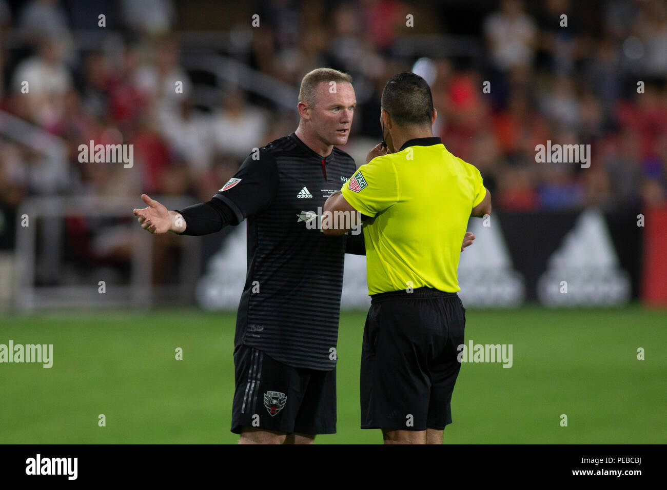 Washington, United States. 14 juillet, 2018. D.C. United Wayne Rooney (9) affirme avec arbitre Hilario Grajeda pendant le jeu entre D.C. United et les Whitecaps de Vancouver à Audi a déposé à Washington, DC Le 14 juillet 2018. C'est DC United's premier jeu au nouveau domaine et Rooney's débuts pour D.C. United. Crédit : l'accès Photo/Alamy Live News Banque D'Images