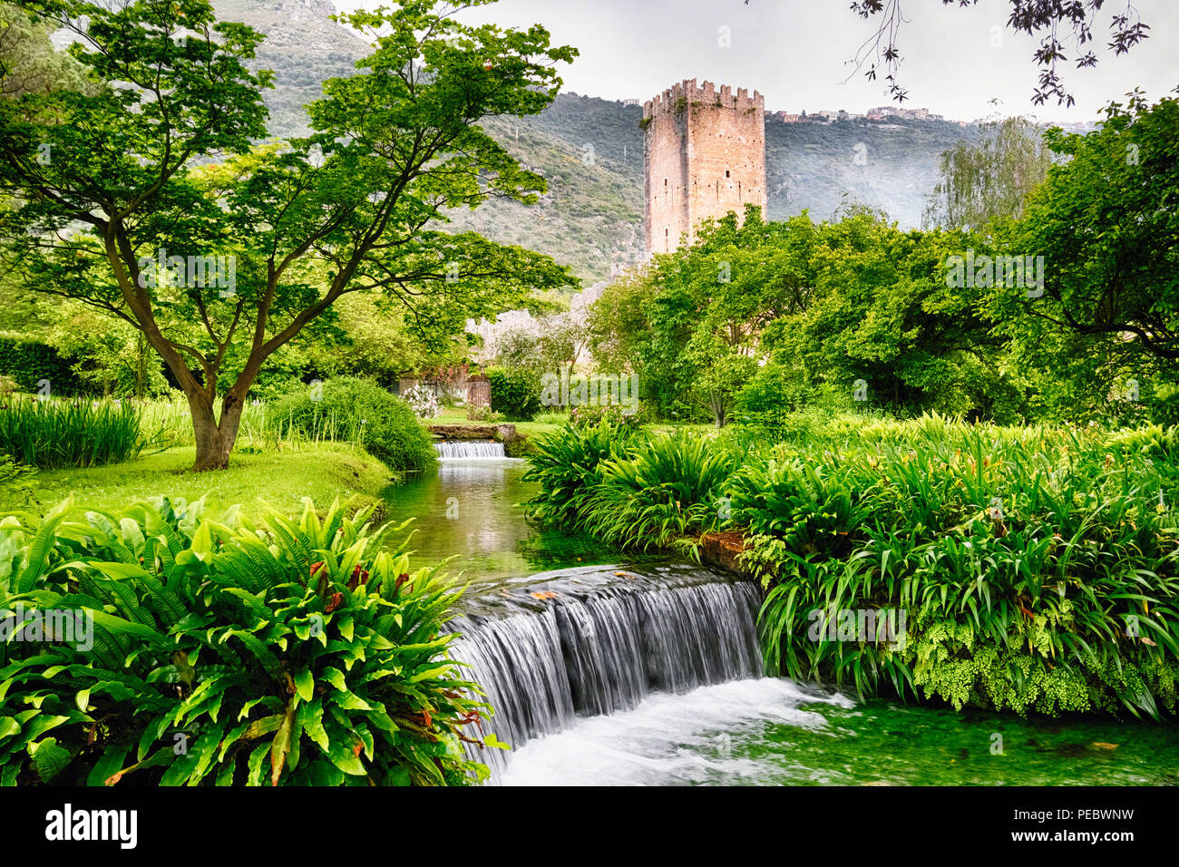 Ruisseau en cascade dans un jardin doté d'une tour médiévale, Latina Italie Banque D'Images