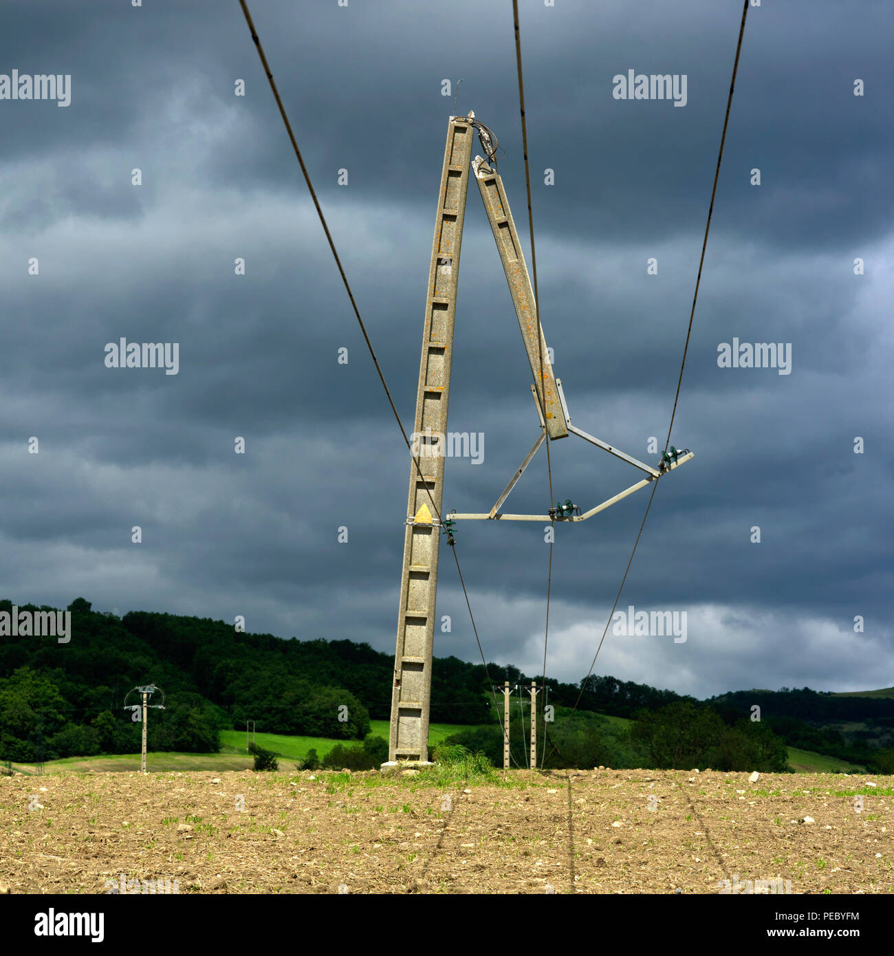 Poteau de béton brisé en deux par la tempête dans un champ dans la campagne, ciel d'orage, Auvergne, France, Europe Banque D'Images