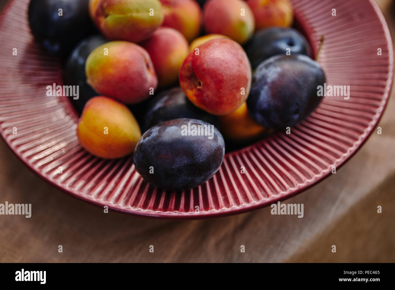Close up d'abricots mûrs et les prunes sur la plaque sur la table Banque D'Images