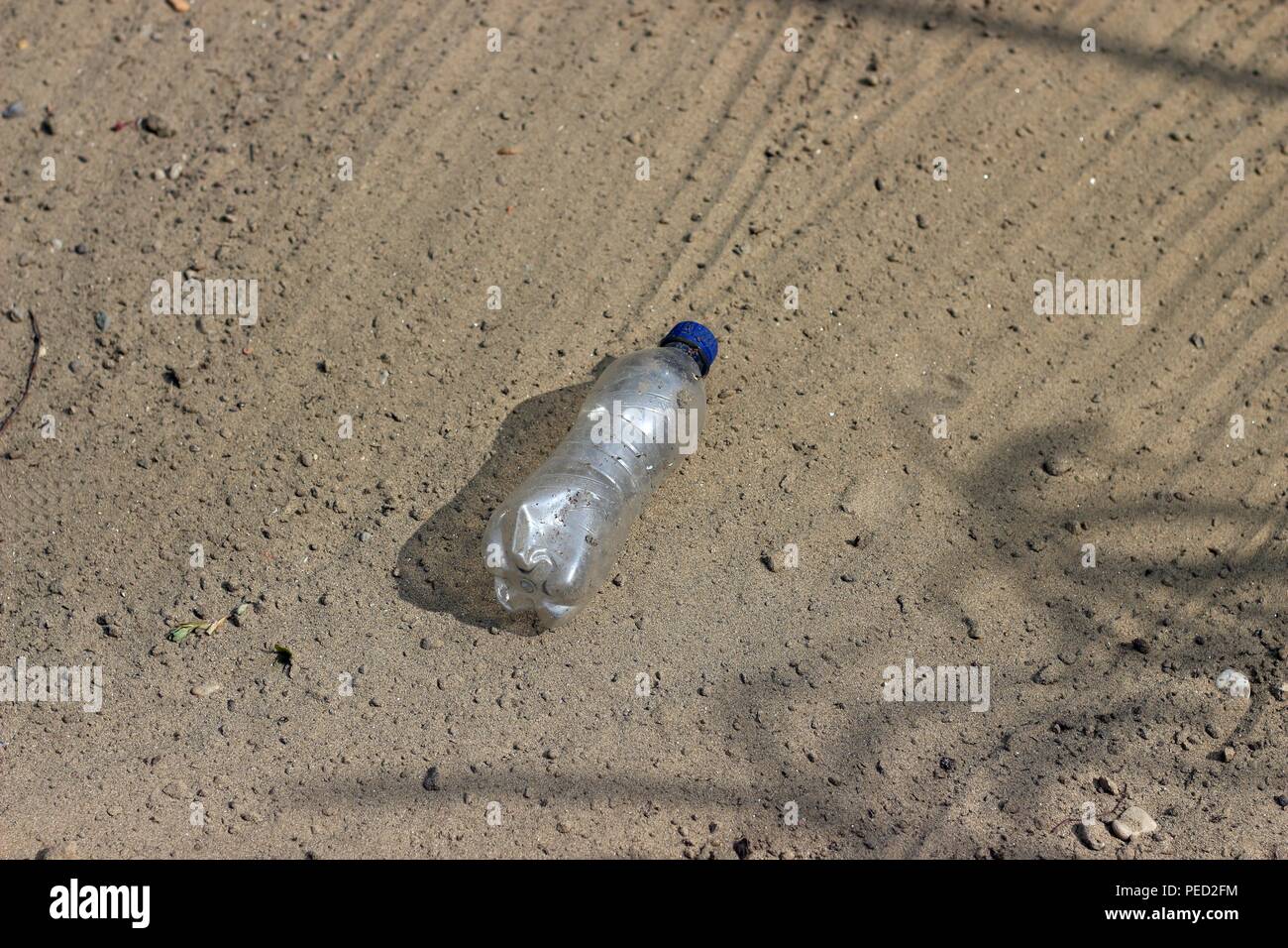 Bouteille en plastique dans le sable Banque D'Images