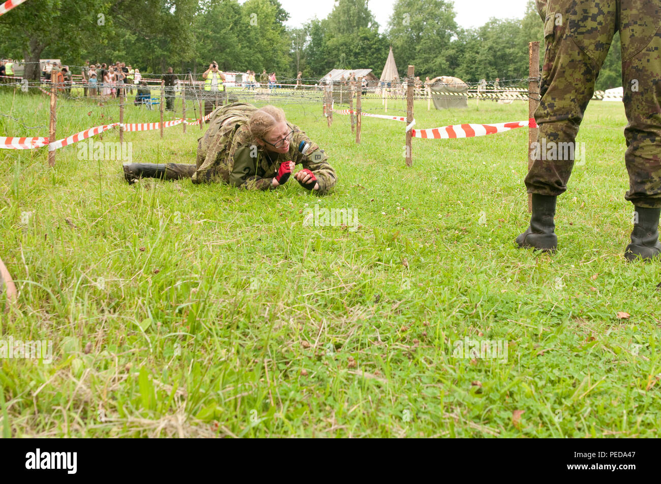 Lisette Tohus, membre de l'Estonian Women's Voluntary Organisation de défense, fait son chemin dans le cadre d'un fil de fer barbelé à étirer le parcours du 7 août, au cours de la 3e journée de l'amiral Pitka Recon Défi en rouge, de l'Estonie. Au cours de ce défi, les participants doivent parcourir 150 km à différents points qu'à l'épreuve leur force physique et mentale. (U.S. Photo de l'armée par le Sgt. Juana M. Nesbitt, 13e Détachement des affaires publiques) Banque D'Images