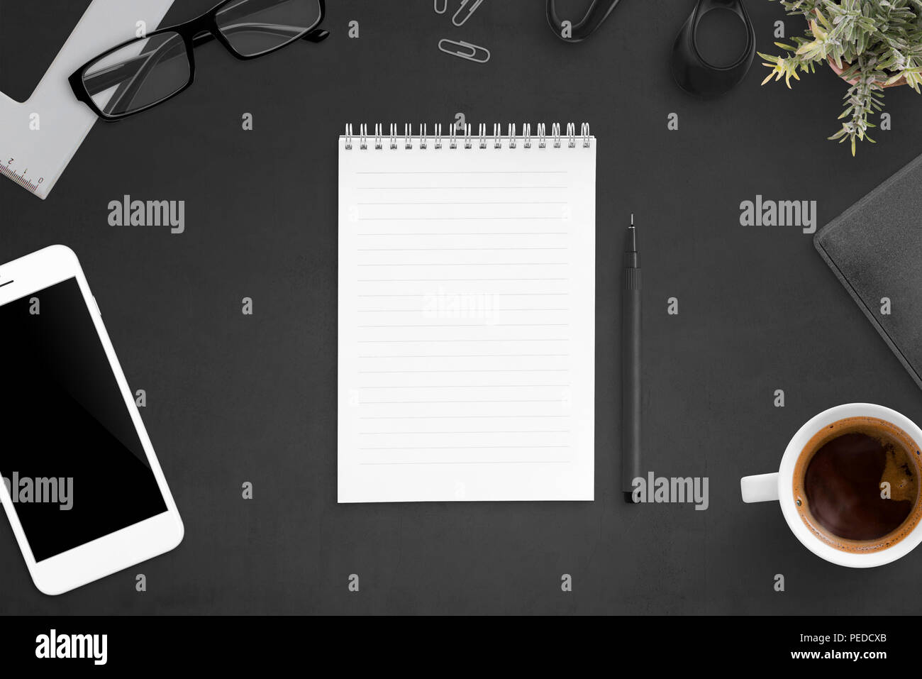 Ordinateur portable sur bureau noir entouré d'accessoires de bureau. Papier blanc, télévision lay. Banque D'Images