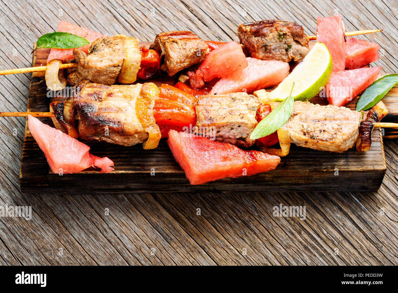 La viande, le shish kebab sur les brochettes avec la pastèque. Recette d'été pour shish kebab Banque D'Images