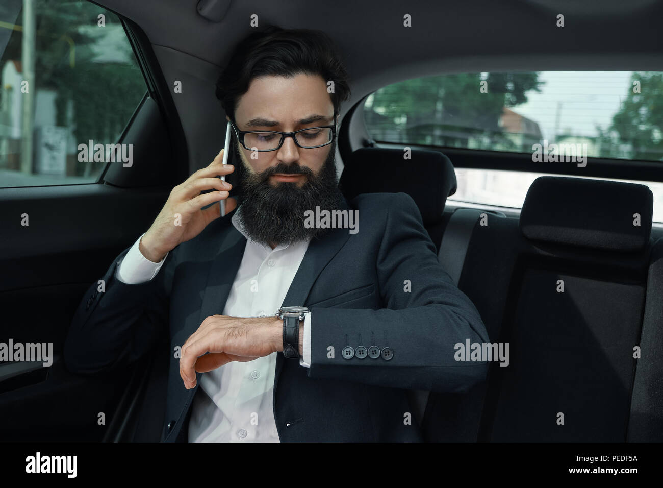 Un homme d'affaires tout en voyageant en voiture sur le siège arrière à l'aide d'un sm Banque D'Images