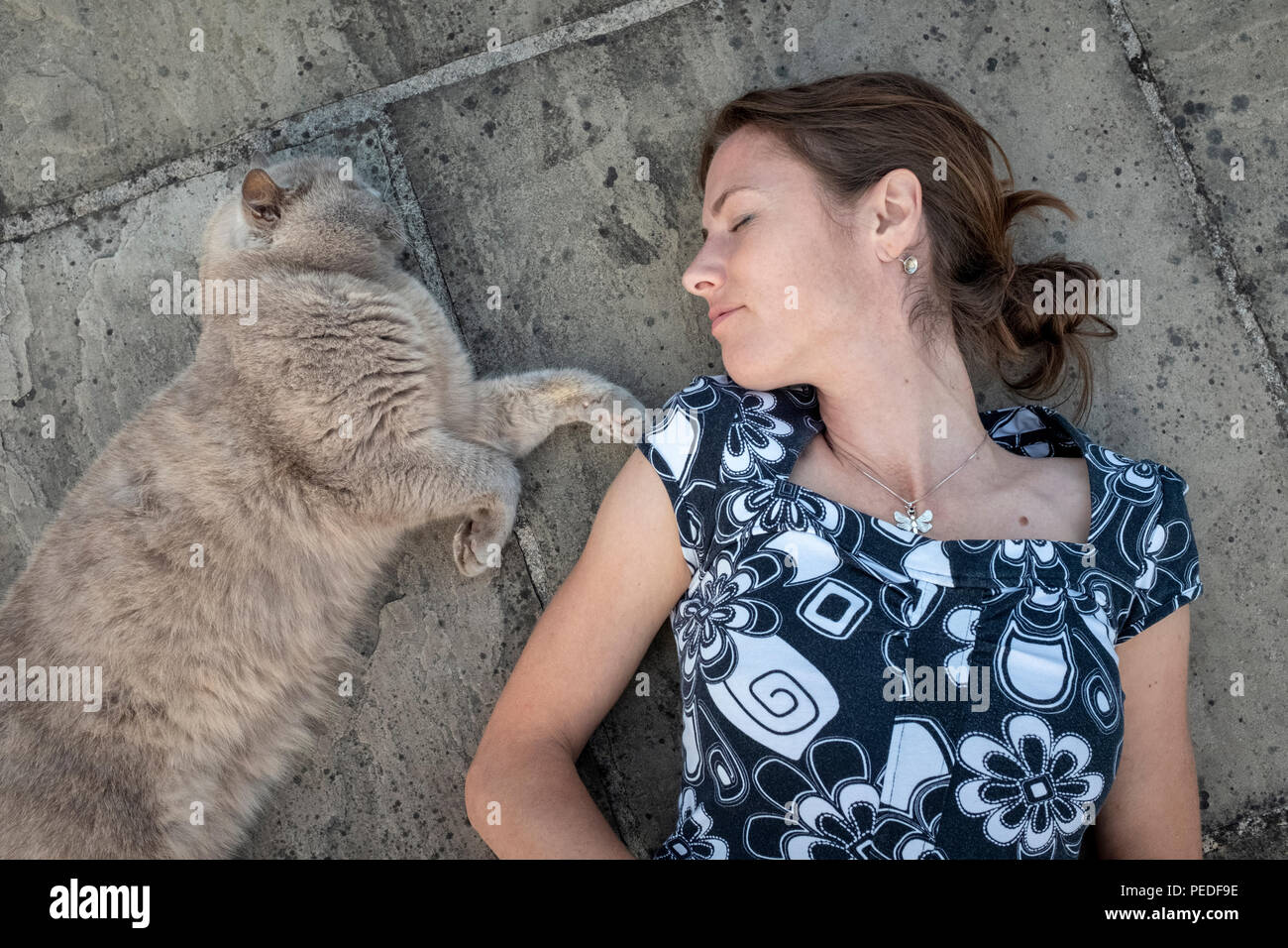 Une femme et son chat couché ensemble sur le terrain. Banque D'Images