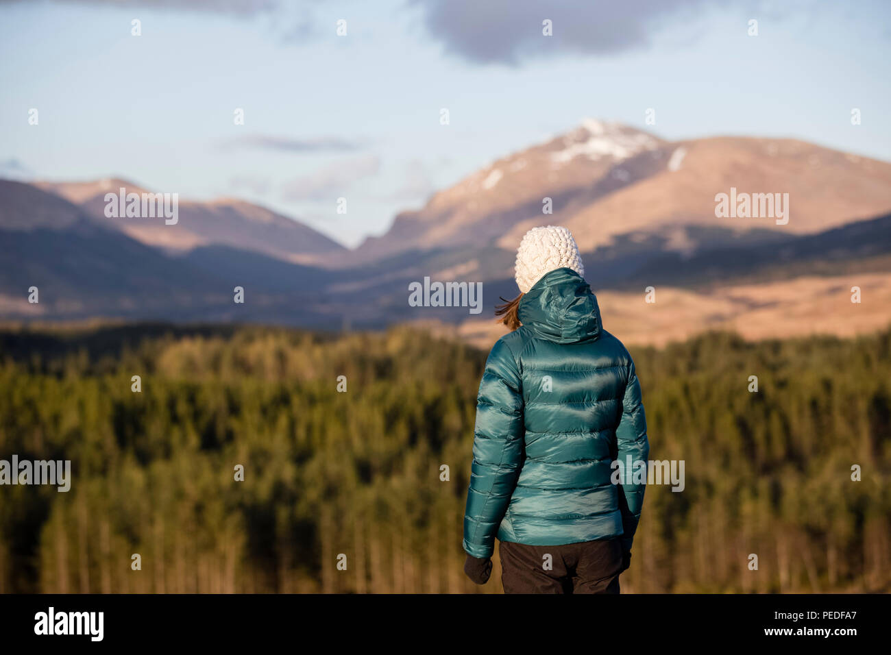 Une jeune femme à la montagne vers un paysage écossais. Banque D'Images