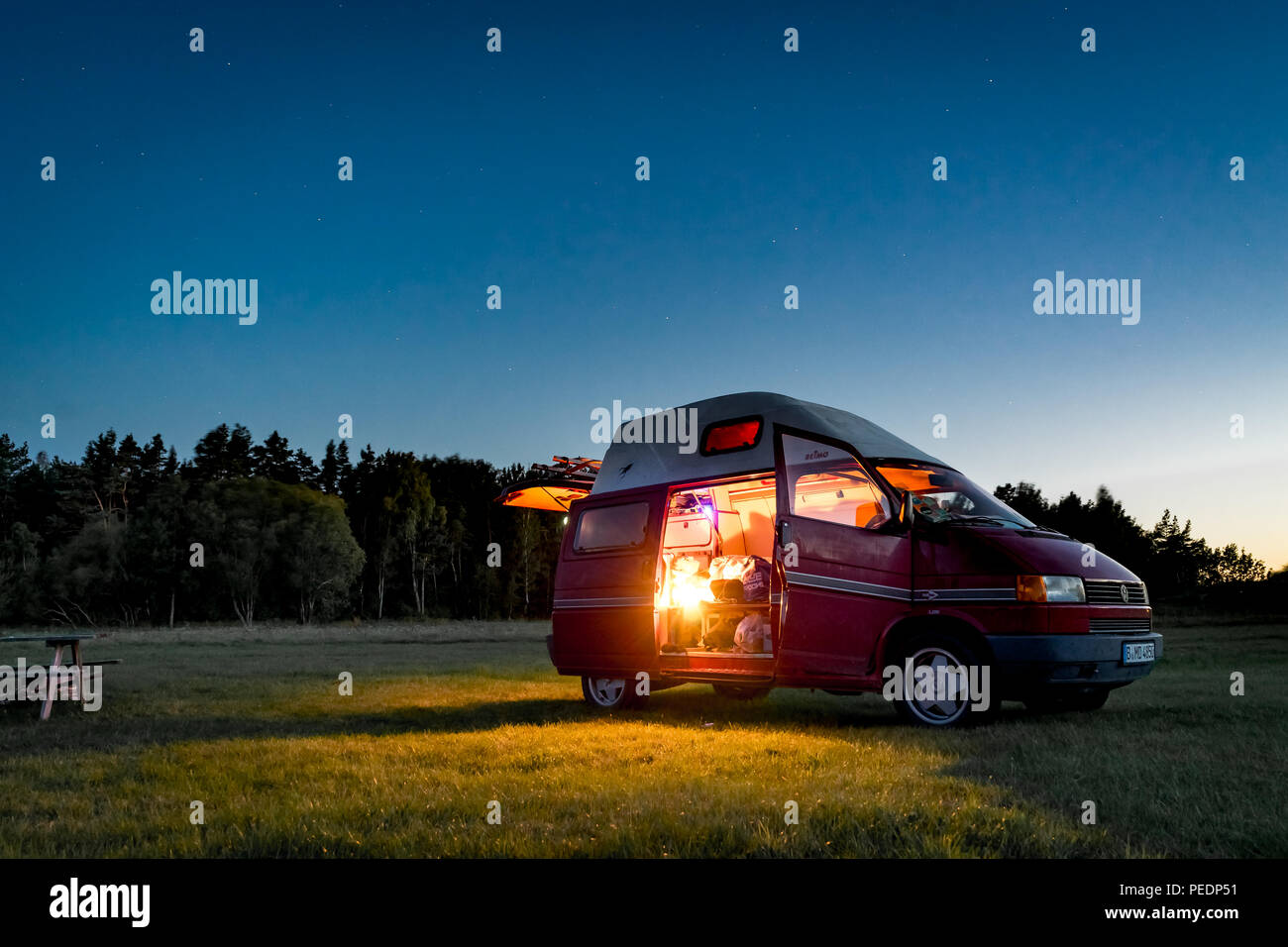Lituanie - Août 2018 : VW Transporter T4 pendant la nuit sur un terrain de camping en Lituanie avec la lumière à l'intérieur. Vue vers le ciel et les étoiles dans le backgrou Banque D'Images