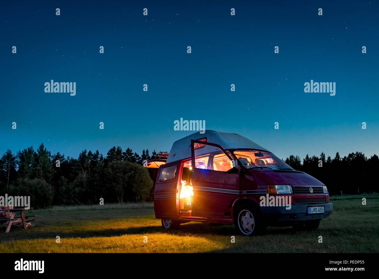 Lituanie - Août 2018 : VW Transporter T4 pendant la nuit sur un terrain de camping en Lituanie avec la lumière à l'intérieur. Vue vers le ciel et les étoiles dans le backgrou Banque D'Images