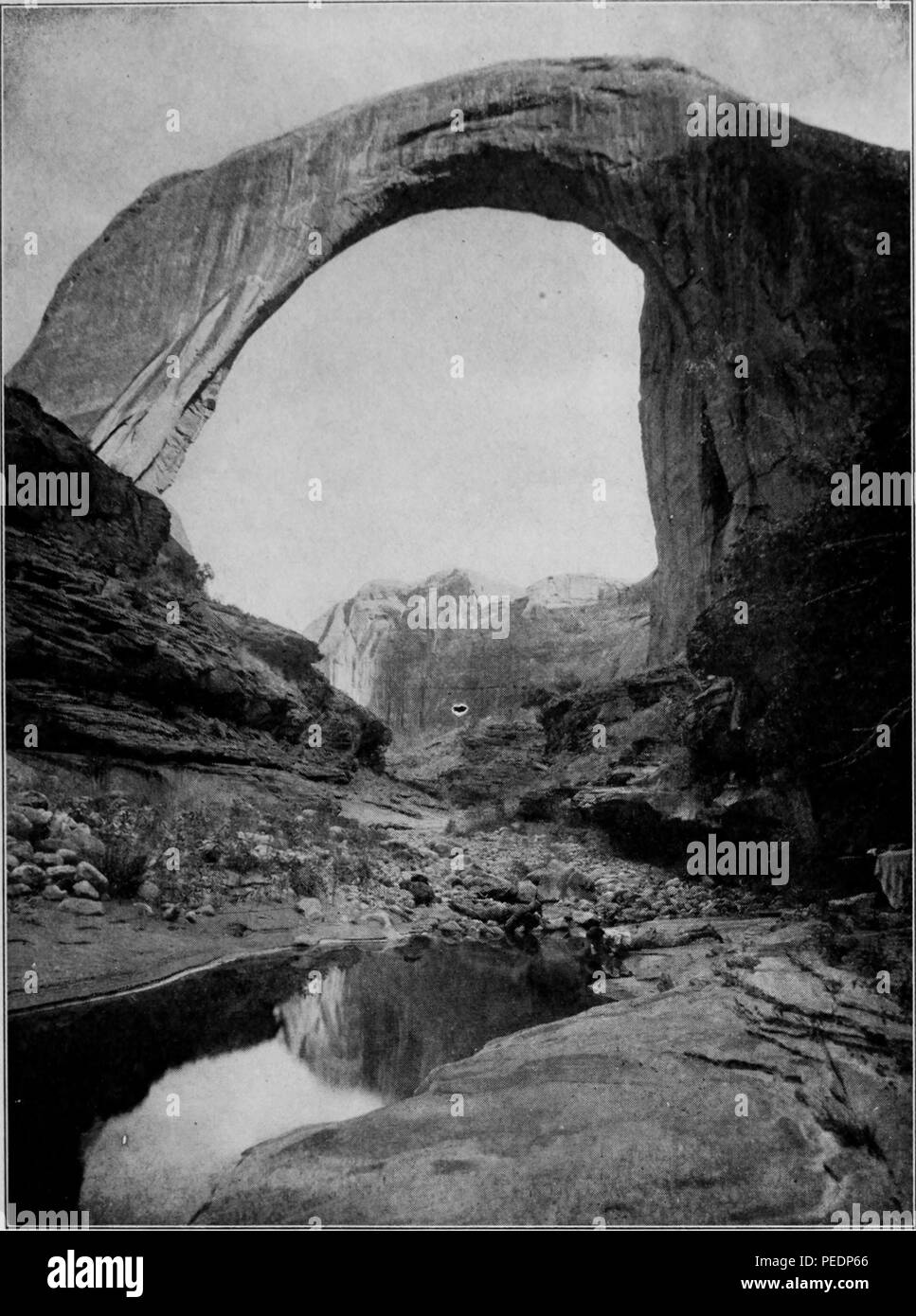 Photographie noir et blanc montrant une vue de la 'Rainbow Bridge National Monument, ''un pont en grès naturel, que l'on croit être les plus élevés du monde, situé dans le sud de l'Utah, USA, 1920. Avec la permission de Internet Archive. () Banque D'Images